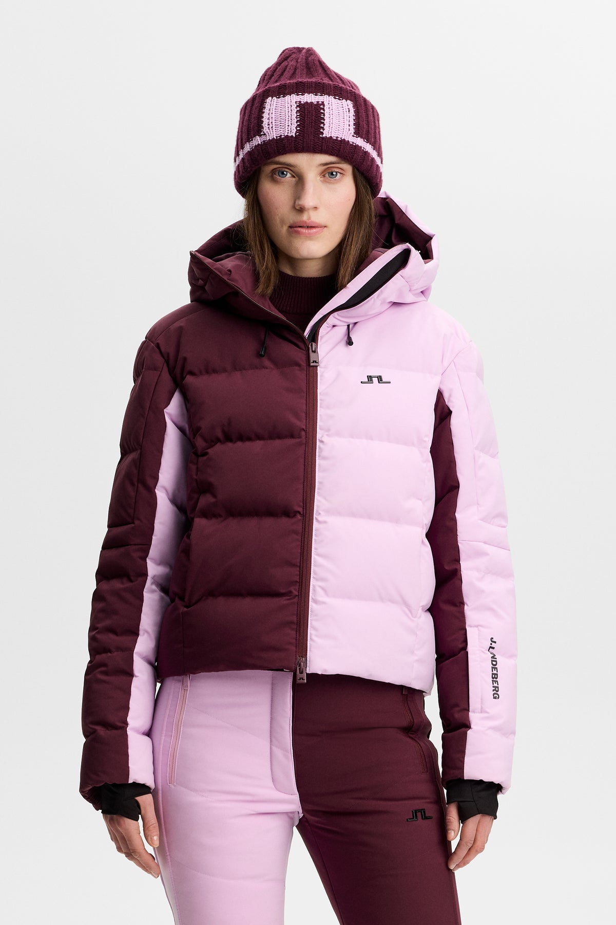 Vorderansicht: Nerina Blocked Down Jacket in Winetasting mit Color-Block-Design, Kapuze und Bridge-Logo auf der Brust.