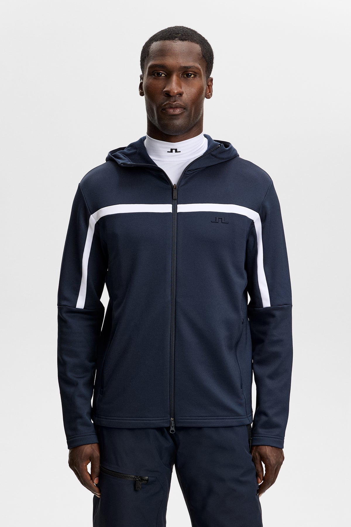 Sett forfra: Sharpe Full Zip Hood i JL Navy på modell, med hette, hel glidelås og hvite kontraststriper.