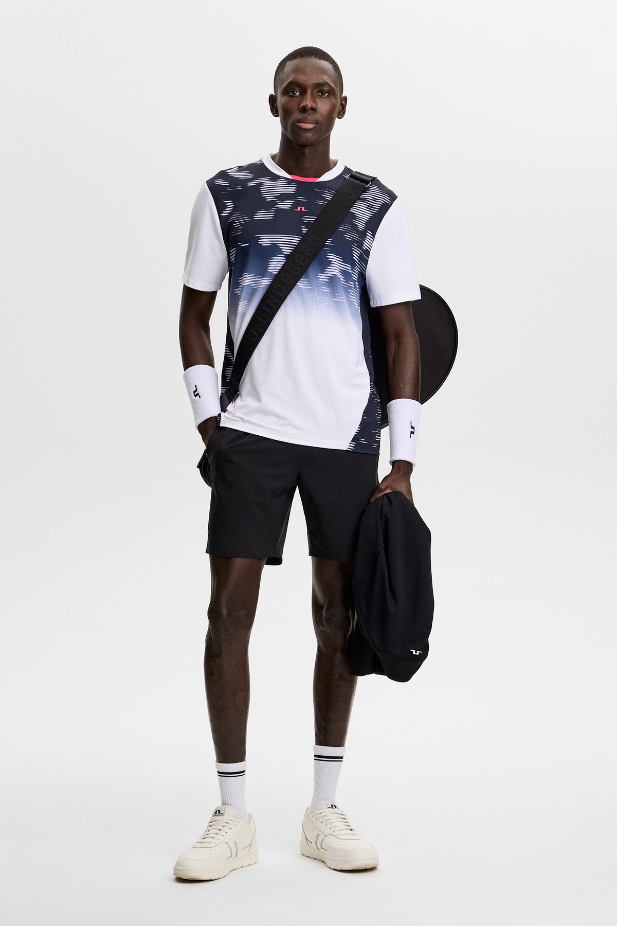 Vooraanzicht: Model draagt het Dennis Printed T-shirt met grafisch kleurverloop, ronde hals en een zwarte short.