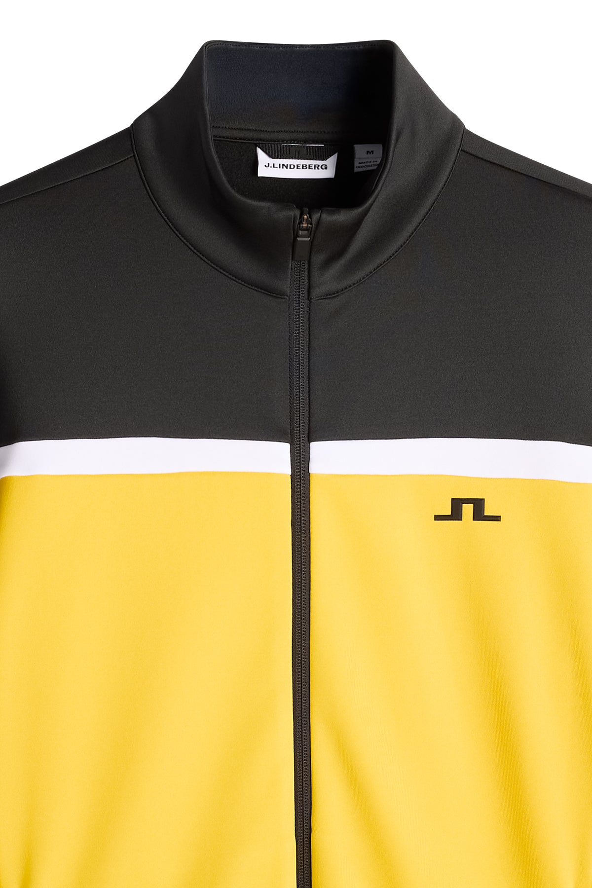 Gros plan : Sharpe Full Zip Mid Layer jaune et noir avec col montant, zip et logo Bridge sur la poitrine.