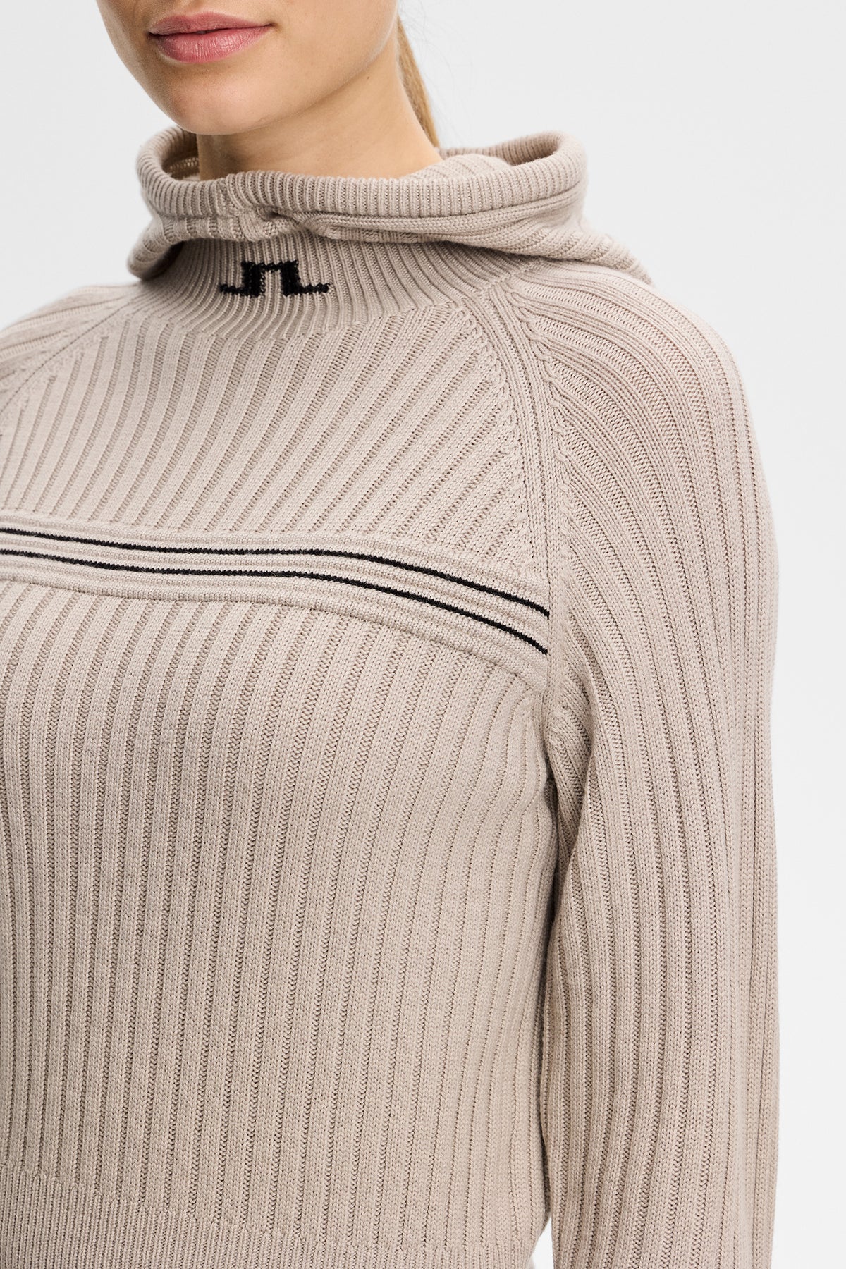 Detailansicht: Hilda Knitted Rib Hoodie in Moonbeam mit Rippstruktur, Kapuze und schwarzem Bridge-Logo am Kragen.