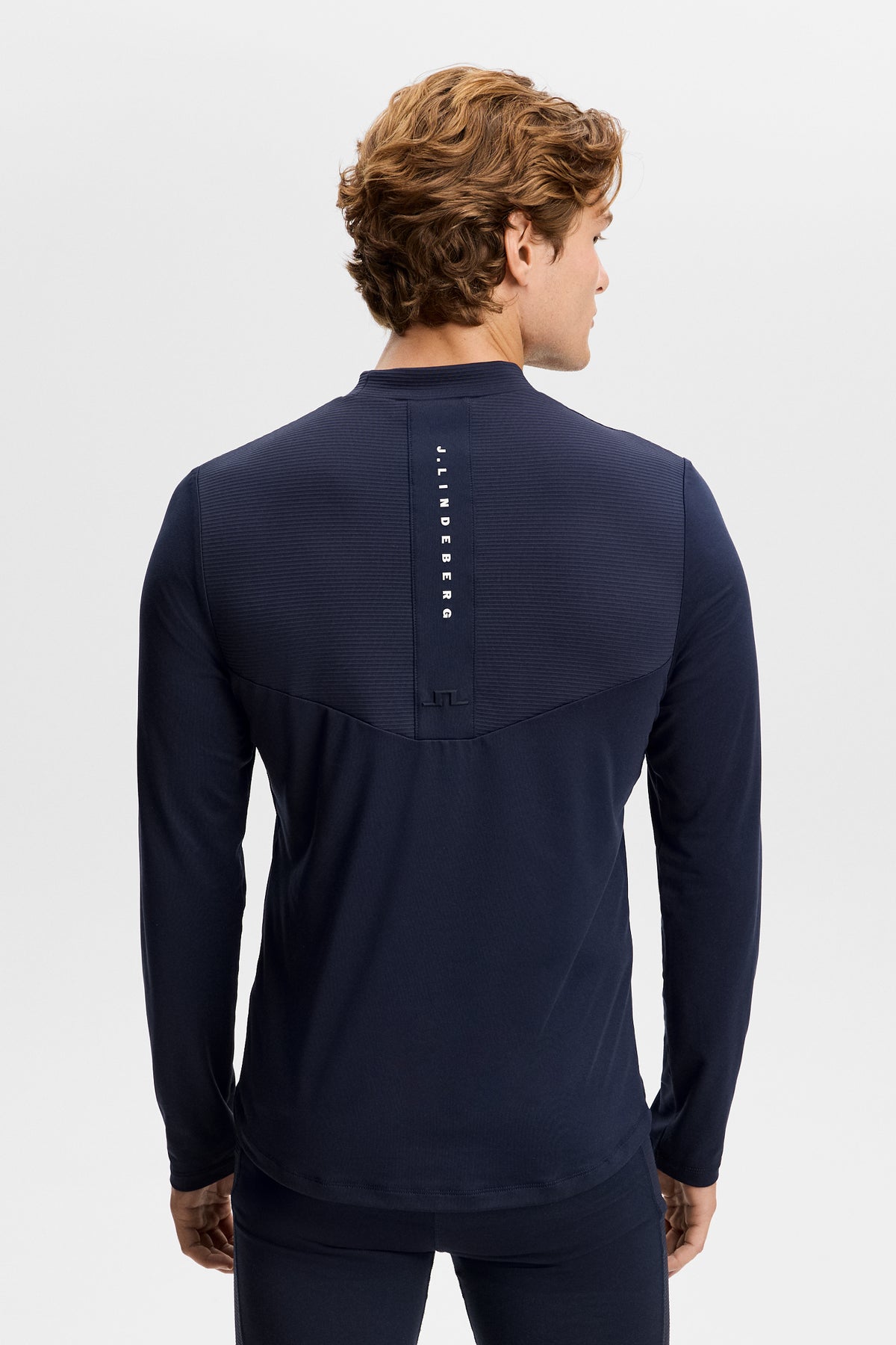 Back view: Zenit Baselayer Top in JL Navy with vertical J.LINDEBERG branding and Bridge logo.