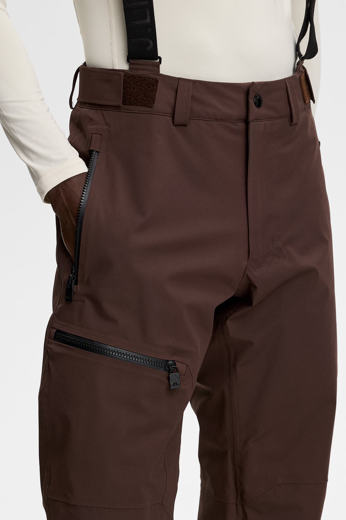 Nærbillede: Crue Suspender Pant i Seal Brown med justerbare seler og lynlåslommer.