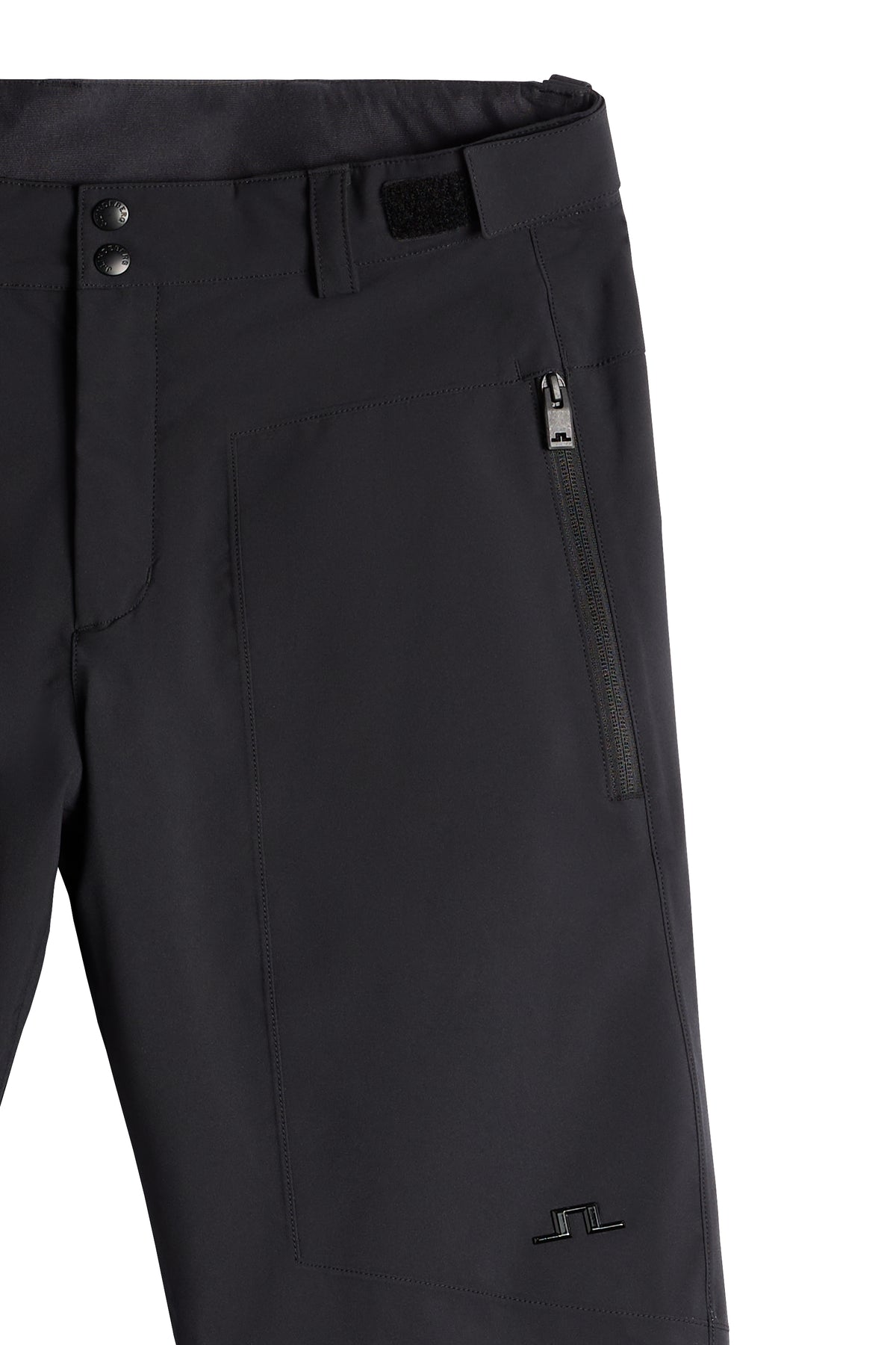 Detailansicht: Schwarze Clarke Pant mit Reißverschlusstasche, Klettverschluss am Bund und Bridge-Logo.