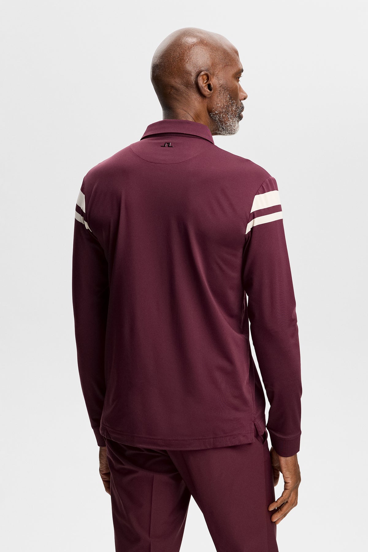 Set bagfra: Kenny LS Stripe Polo i Winetasting med hvide striber på ærmerne og Bridge-logo i nakken.