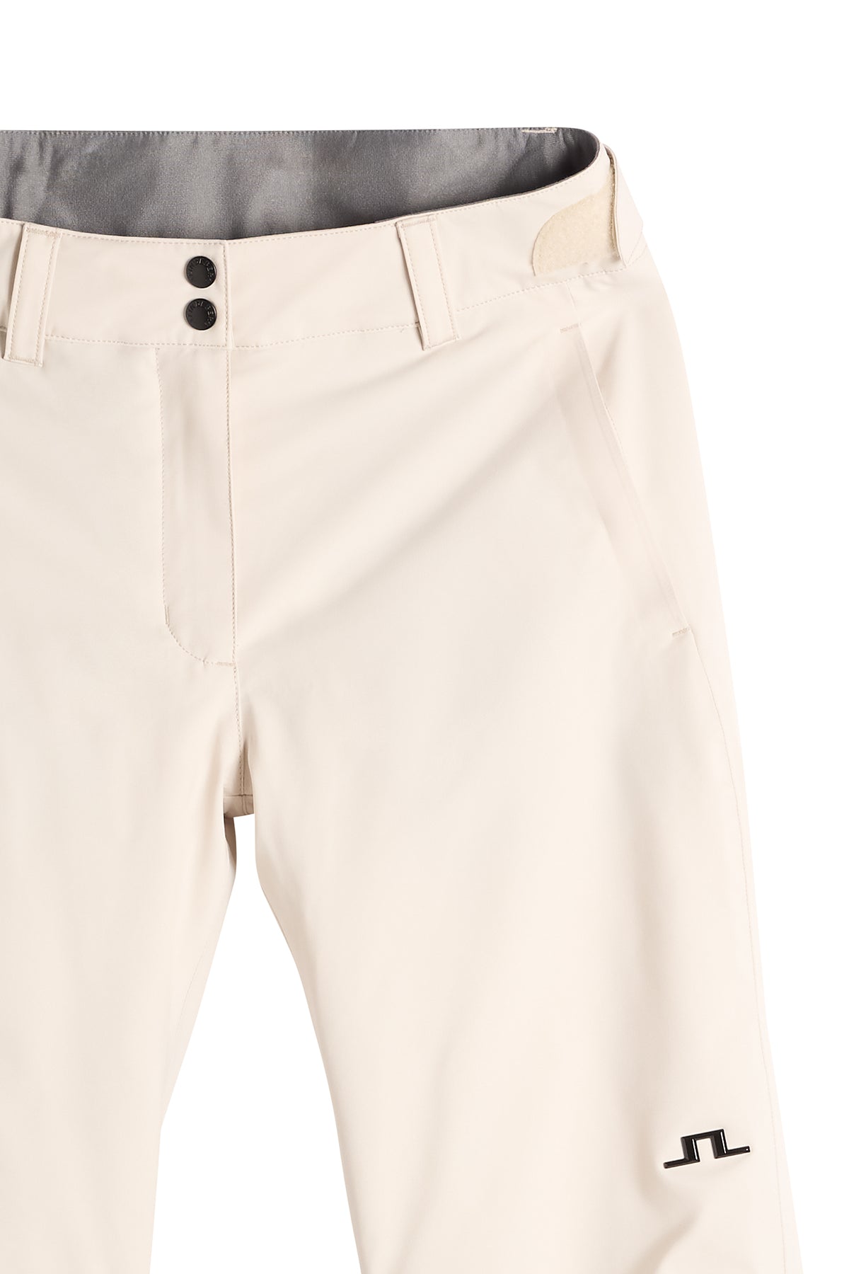Detailansicht: Moeva Pant in Moonbeam mit Bund, Knopfverschluss, Eingrifftasche und Bridge-Logo auf dem Bein.