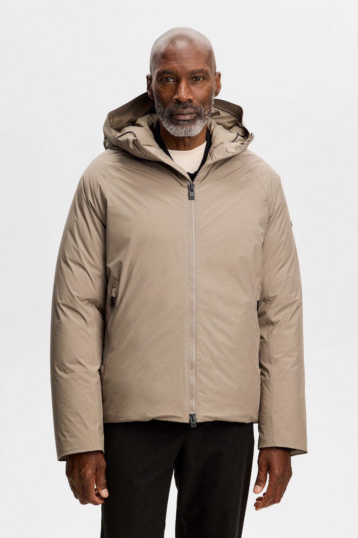 Vooraanzicht: Model draagt de Alvin Down Jacket in Brindle met capuchon en ritssluiting.