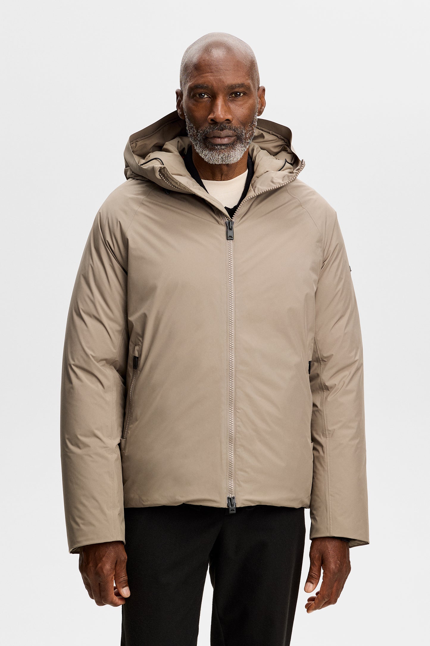 Vooraanzicht: Model draagt de Alvin Down Jacket in Brindle met capuchon en ritssluiting.