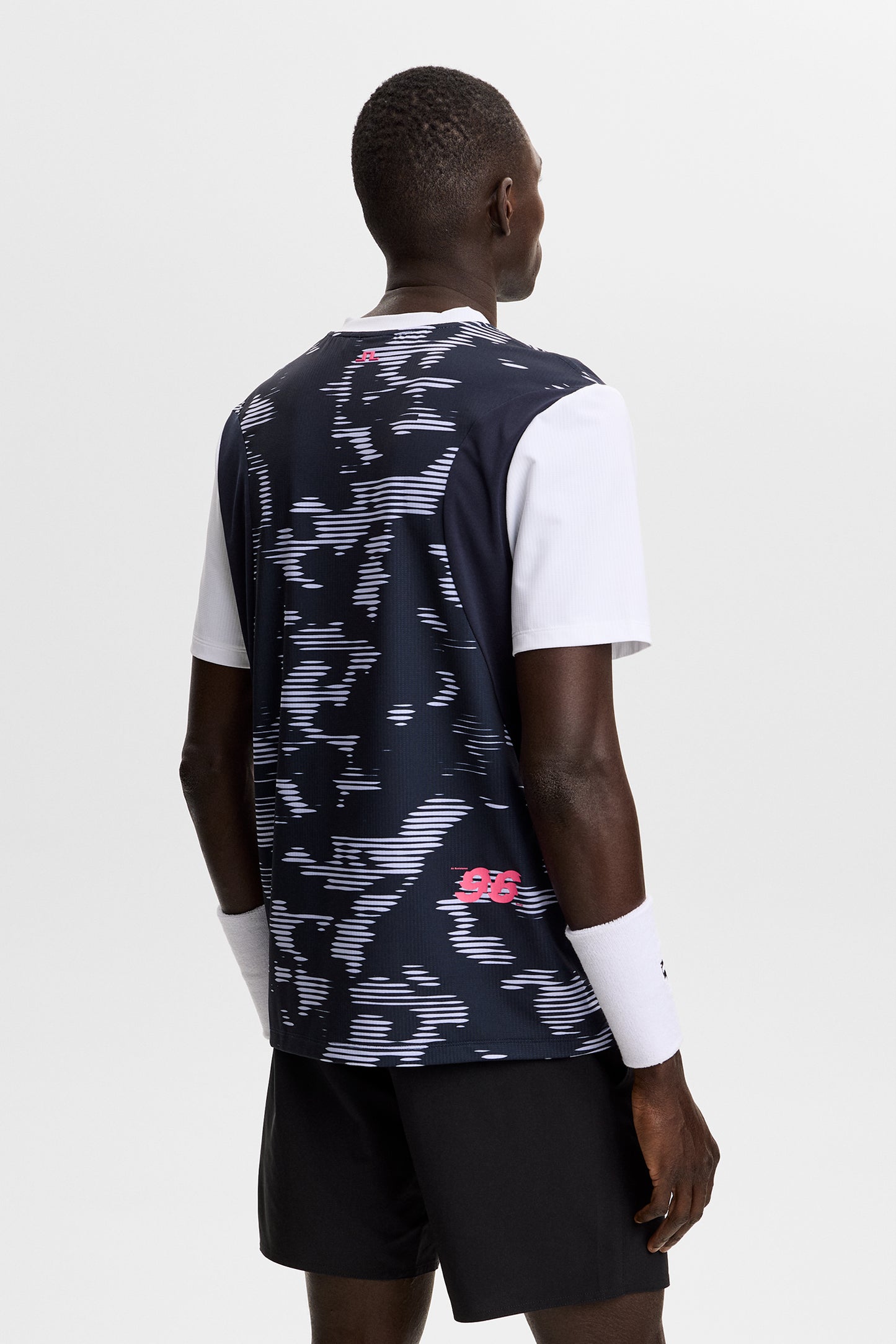 Achteraanzicht: Model draagt het Dennis Printed T-shirt met print op de rug en contrasterende witte korte mouwen.