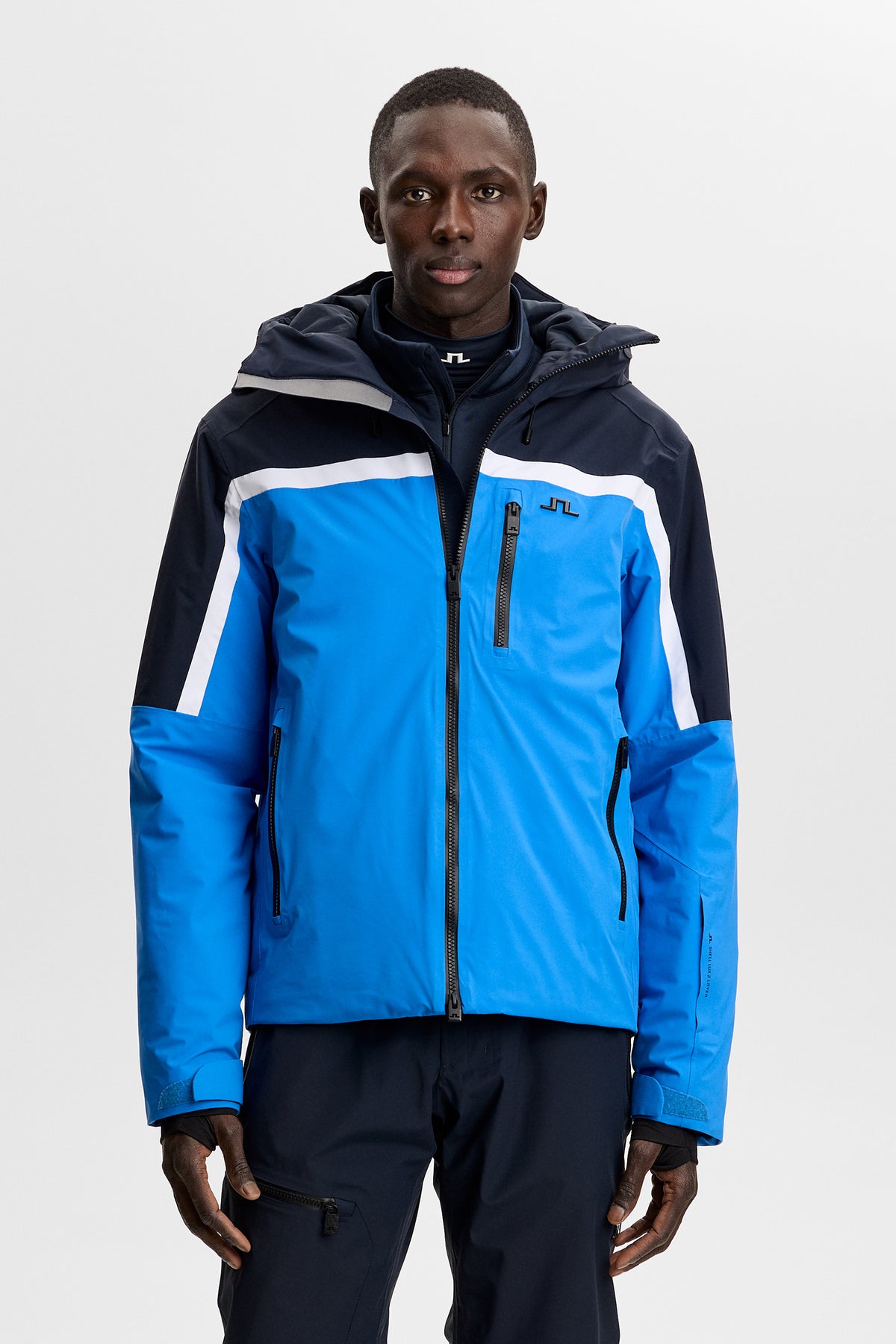Front view: Windsor Jacket in Sonic Blue with color blocking, hood, and Bridge logo at the chest.