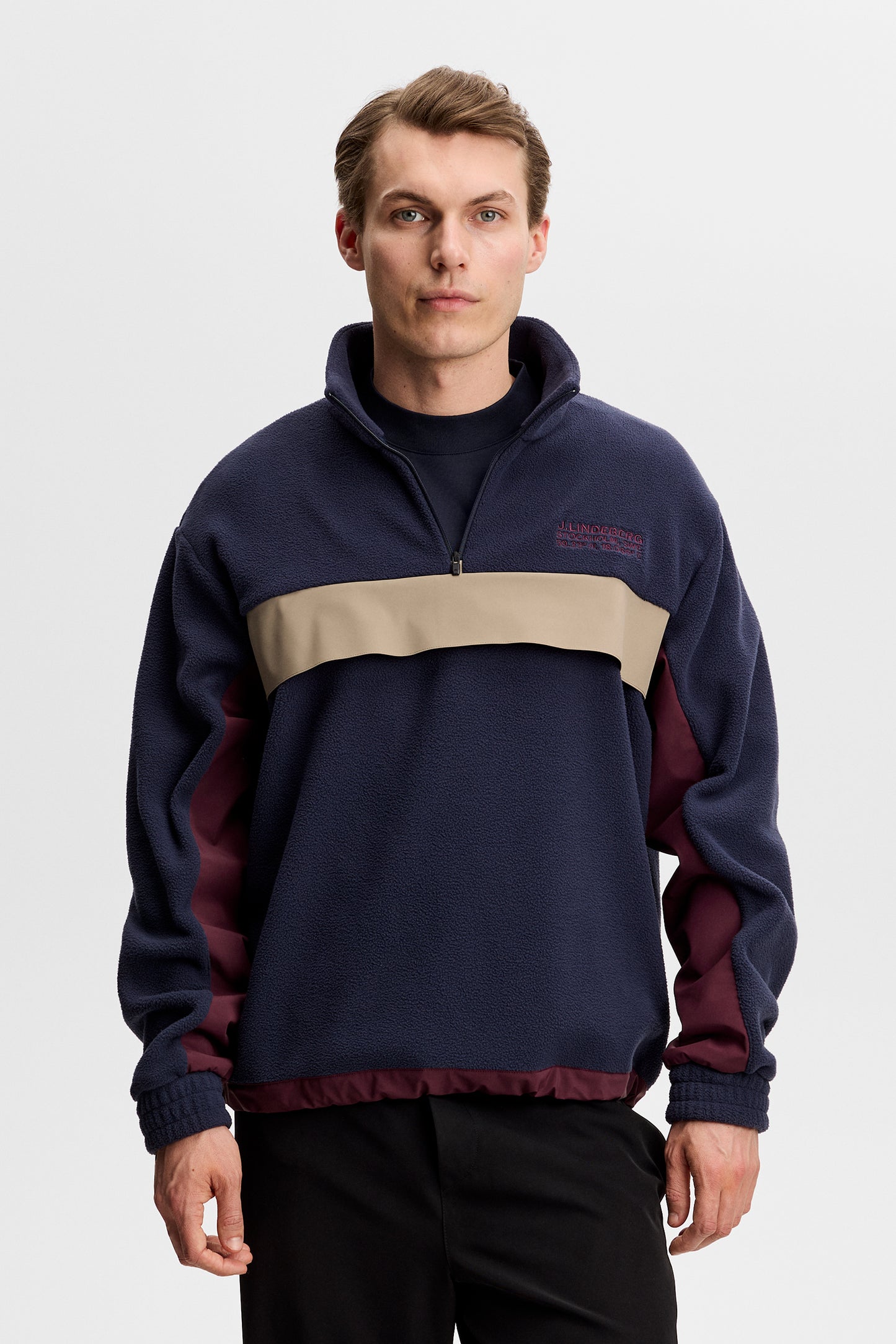 Set forfra: Quinn Hybrid Sweatshirt i JL Navy med kvartlynlås, beige brystpanel og broderet logo på brystet.