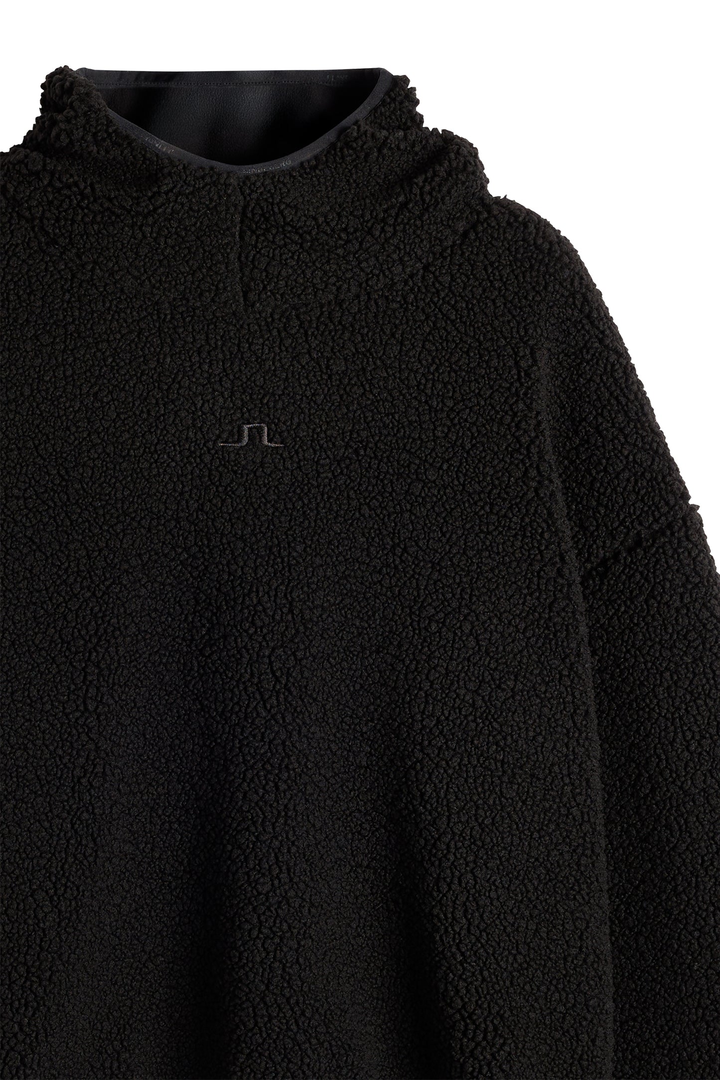 Detailansicht: Schwarzer Comona Pile Hood aus Teddy-Fleece mit tonalem Bridge-Logo auf der Brust.