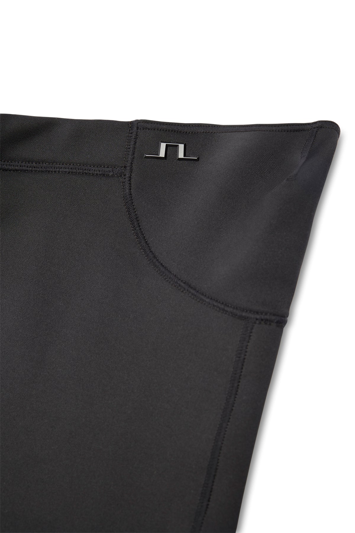 Nærbillede: Sort Thaw Neck Gaiter med gummieret Bridge-logo og flade sømme langs kanten.