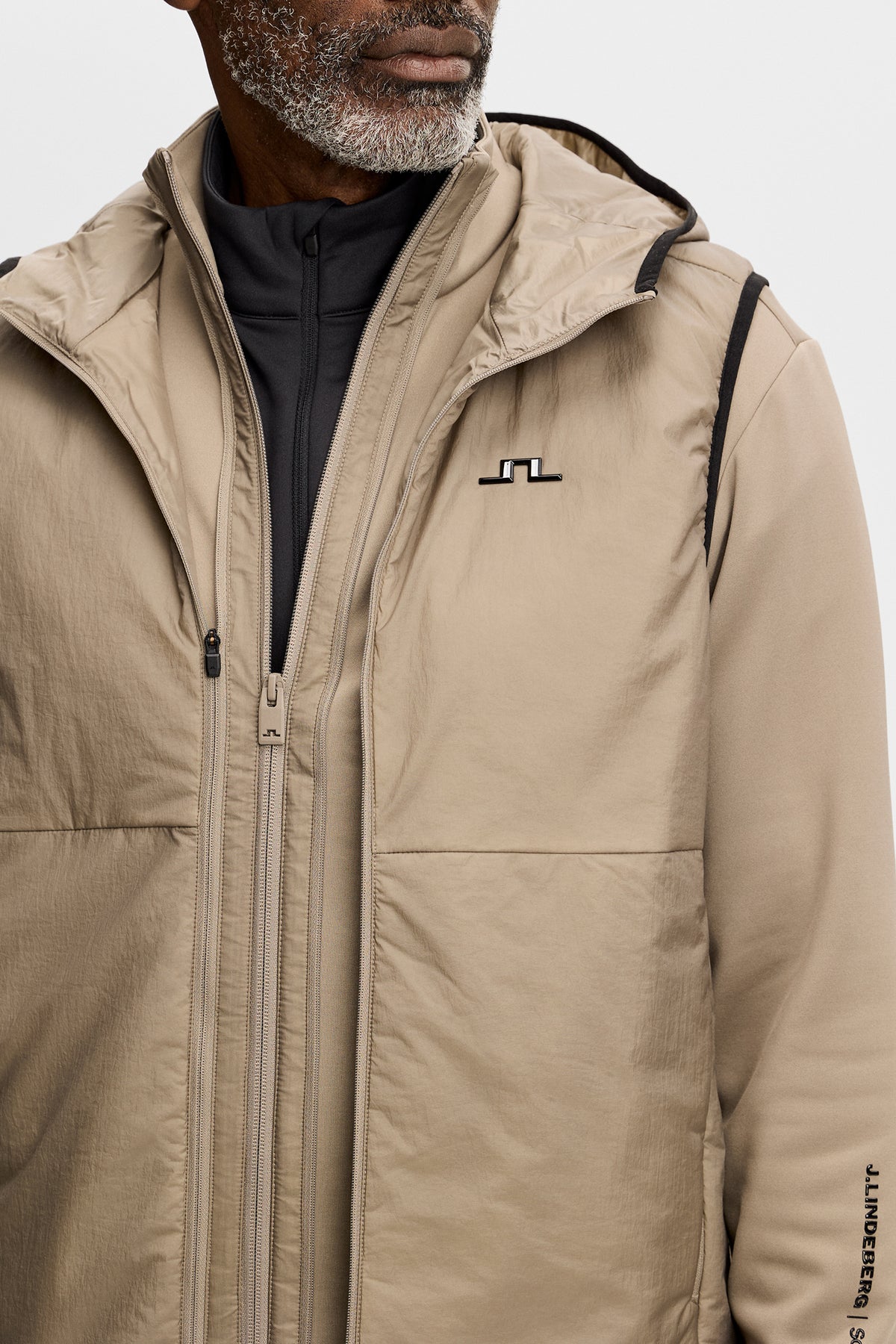 Gros plan : M Solarcore 3 in 1 Jacket brindle avec capuche, fermetures zippées et logo Bridge sur la poitrine.