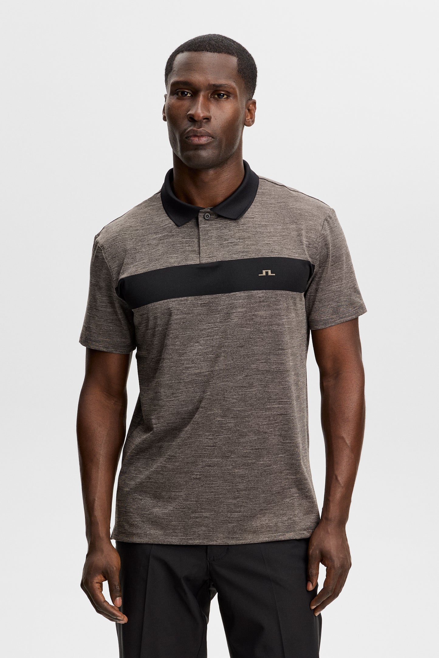 Vorderansicht: Model trägt das Rocky Polo in Brindle-Melange mit schwarzem Bruststreifen und kleinem Bridge-Logo.