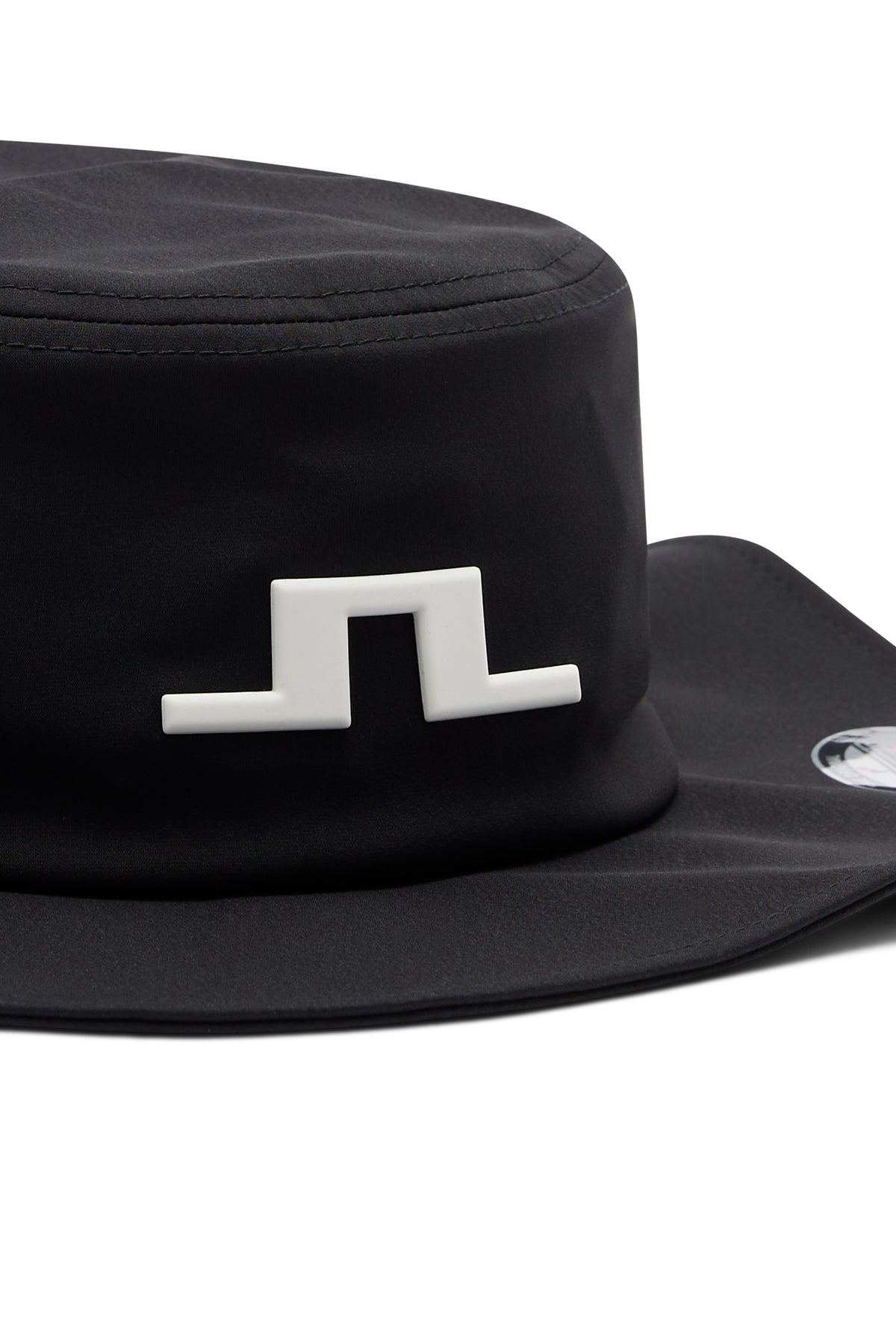 Nærbilde: Svart Tour Flexfit Bucket med hvit Bridge-logo foran og strukturert brem.