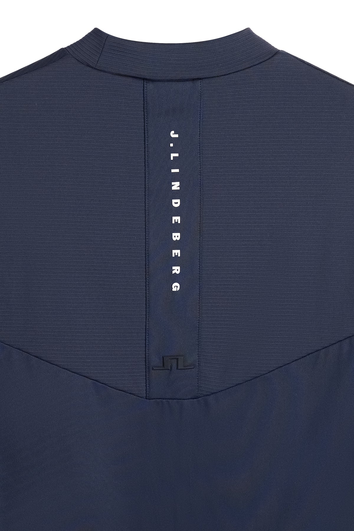 Close-up of vertical J.LINDEBERG branding and Bridge logo on the back of the Zenit Baselayer Top in JL Navy.