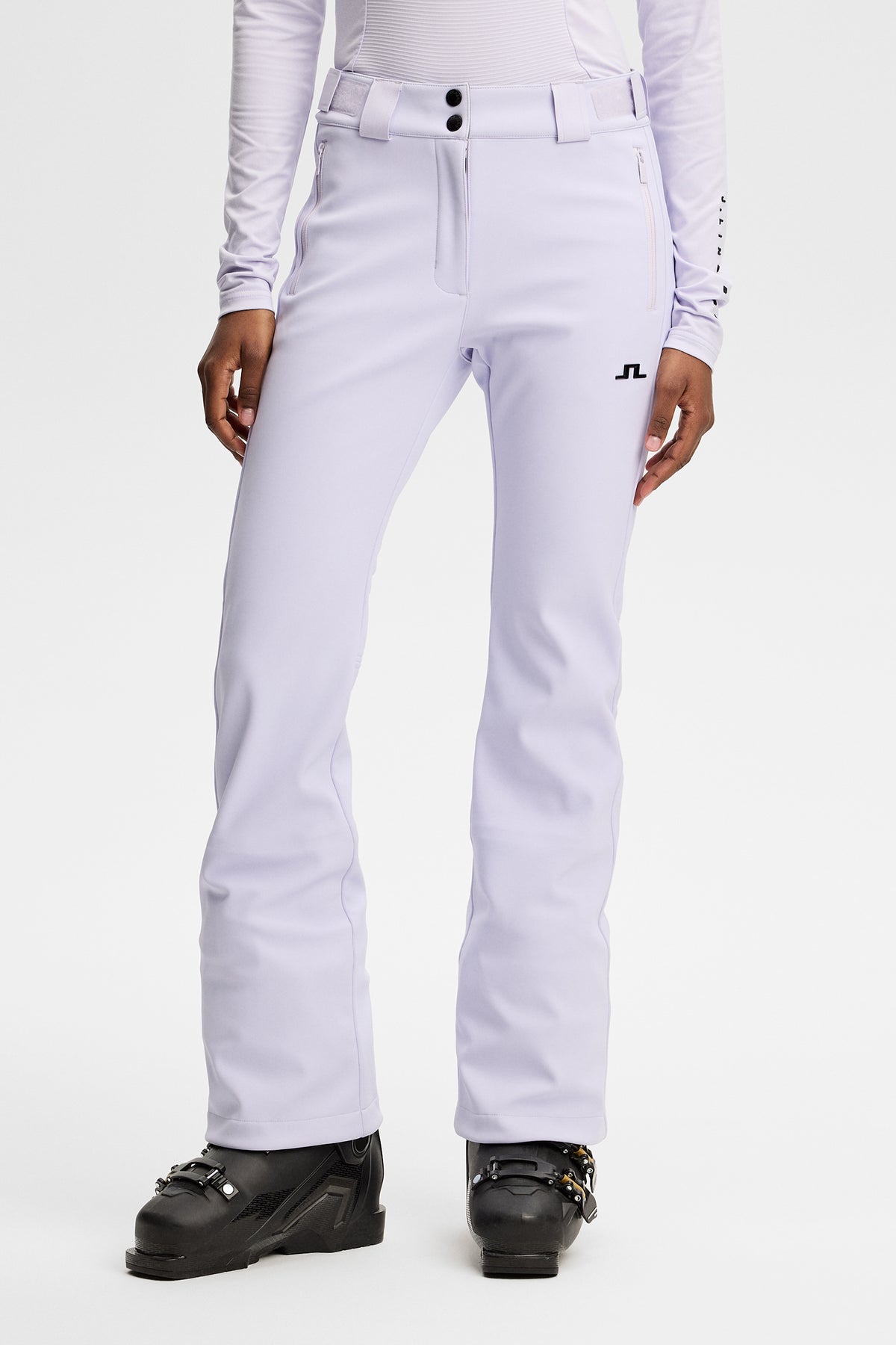 Forfra: Stanford Softshell Ski Pant i Purple Heather med lynlåslommer og sort Bridge-logo på låret.