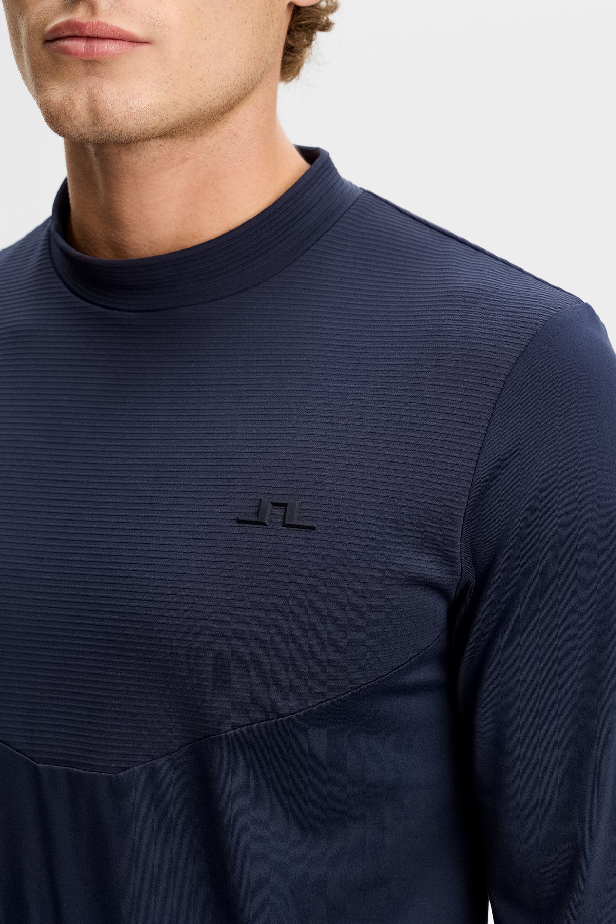 Close-up of the Zenit Baselayer Top in JL Navy, featuring a textured upper chest and tonal Bridge logo.