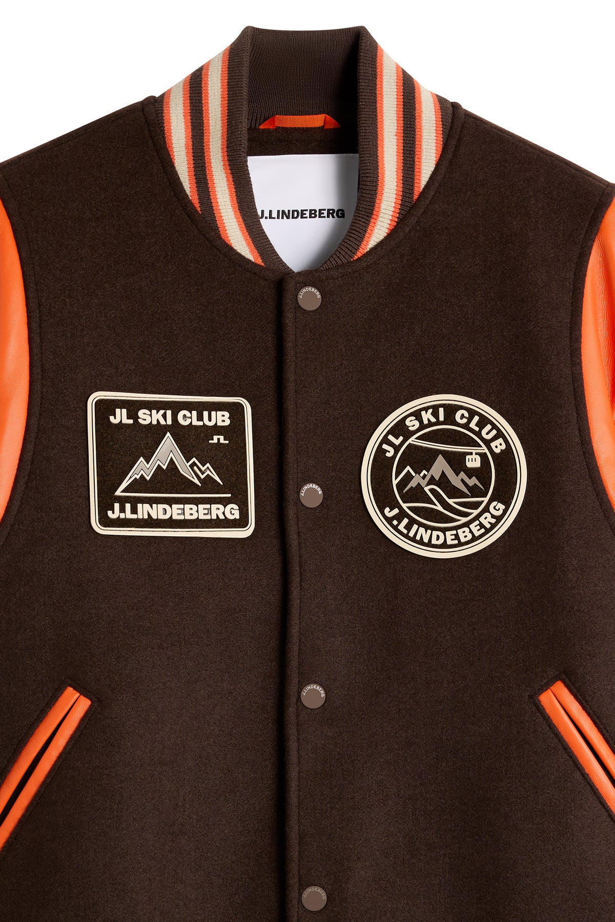 Close-up view: Bobby Bomber Jacket in Seal Brown featuring JL Ski Club chest patches and striped ribbed collar.
