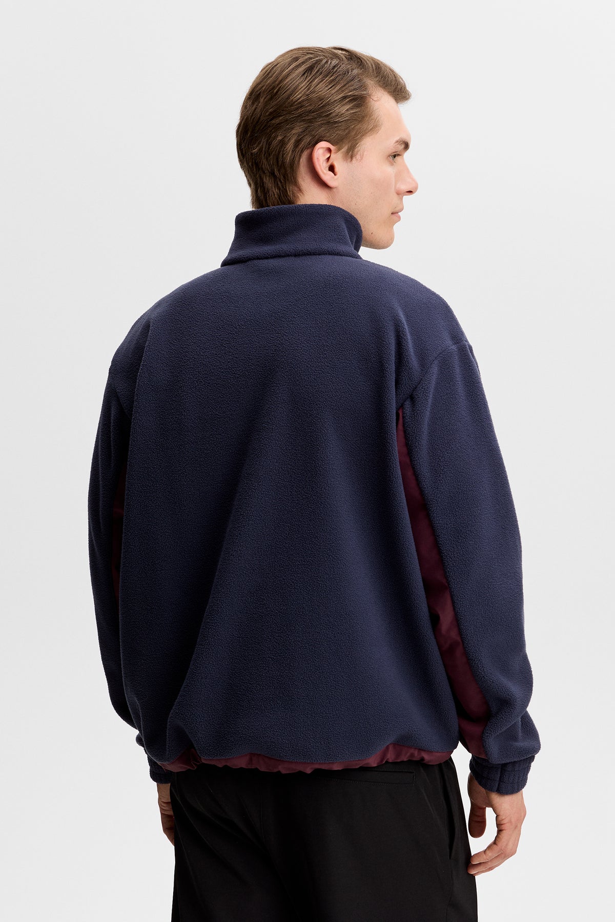 Set bagfra: Quinn Hybrid Sweatshirt i JL Navy med høj krave, fleecestruktur og kontrastpaneler under ærmerne.