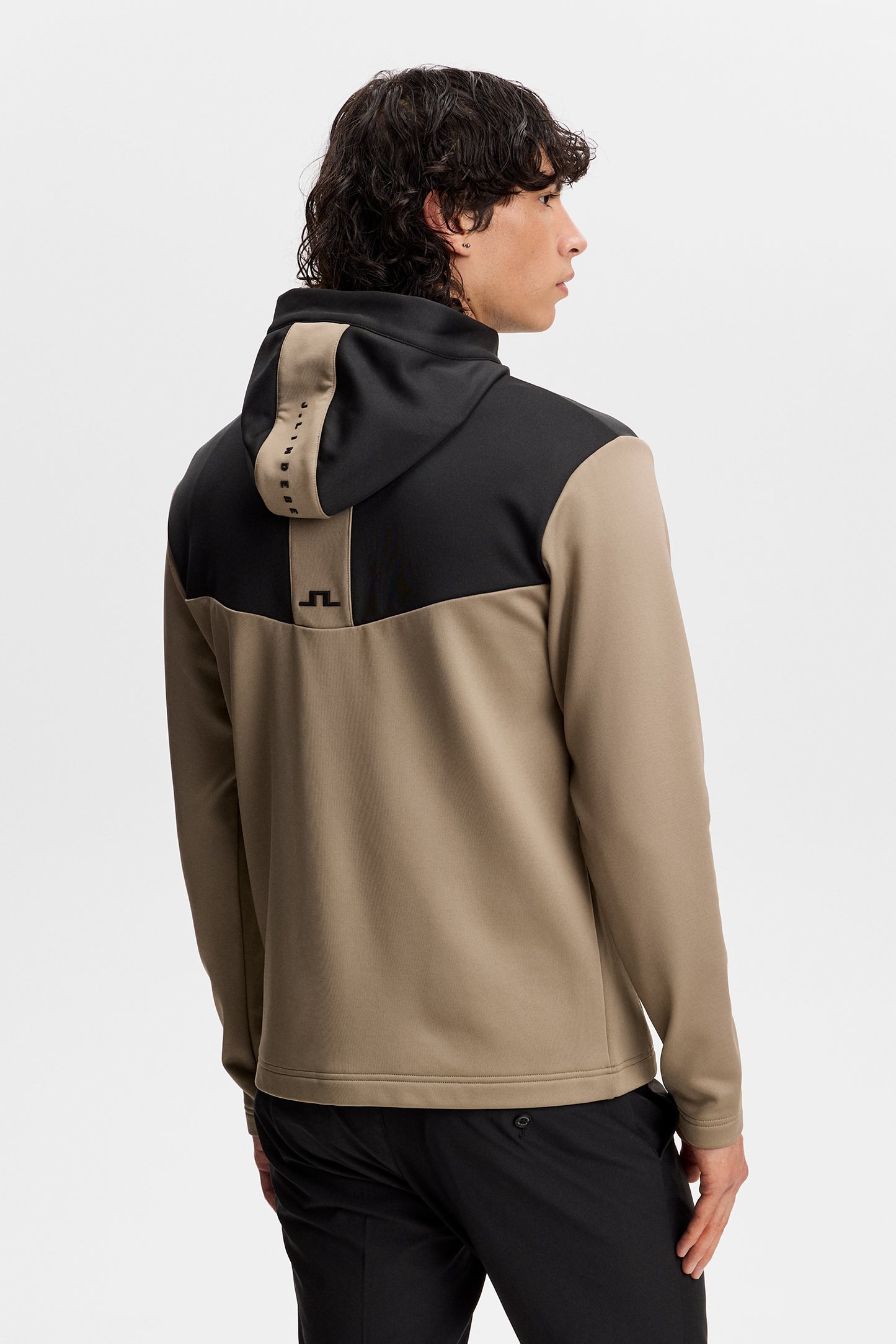 Maclean Zip Hood in beige and black, back view on a model showing the color-blocked yoke and J.Lindeberg hood branding.
