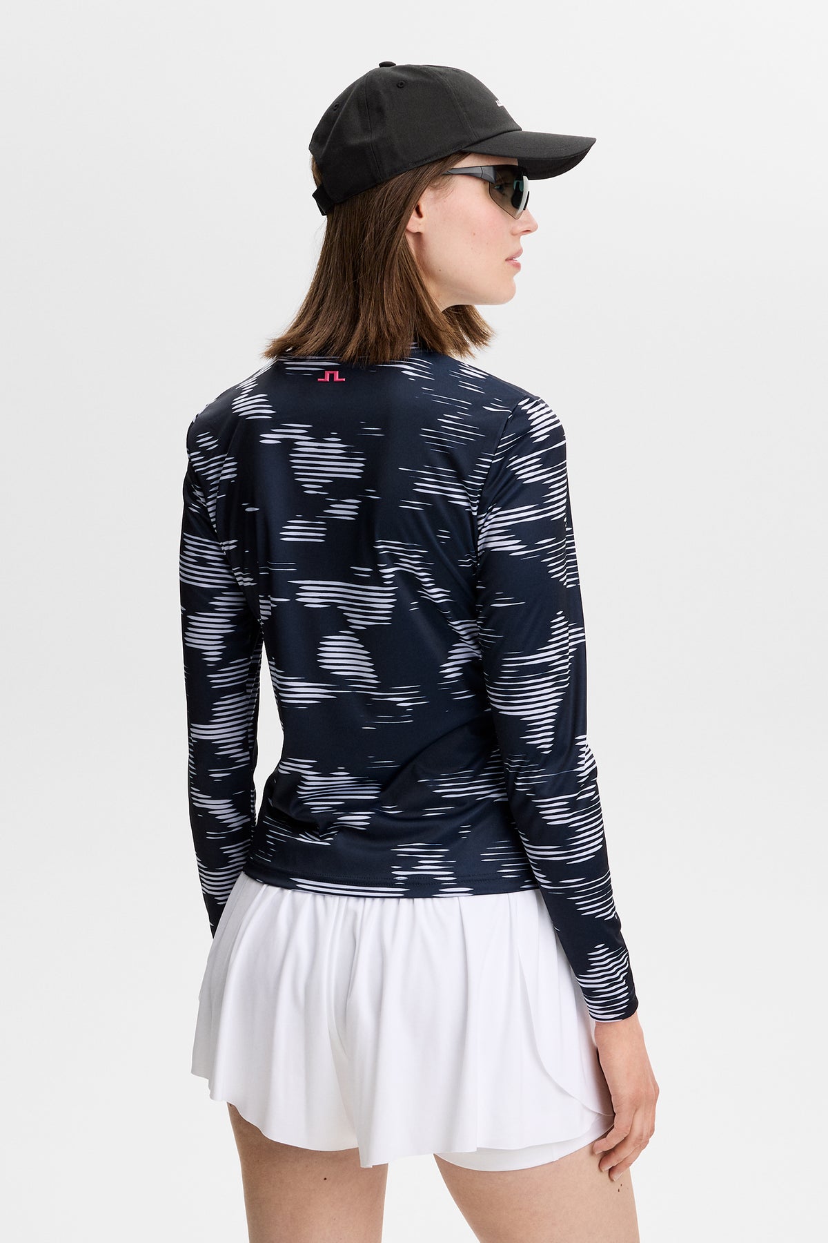 Achteraanzicht: Model draagt de Line LS Printed Top met grafische print, lange mouwen en Bridge-logo in de nek.