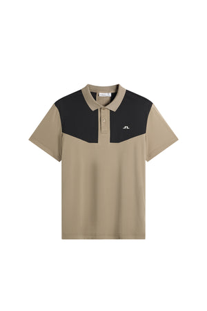 Framifrån: Calex Polo i beige och svart med kontrasterande bröstpanel, krage med knappslå och Bridge-logotyp.