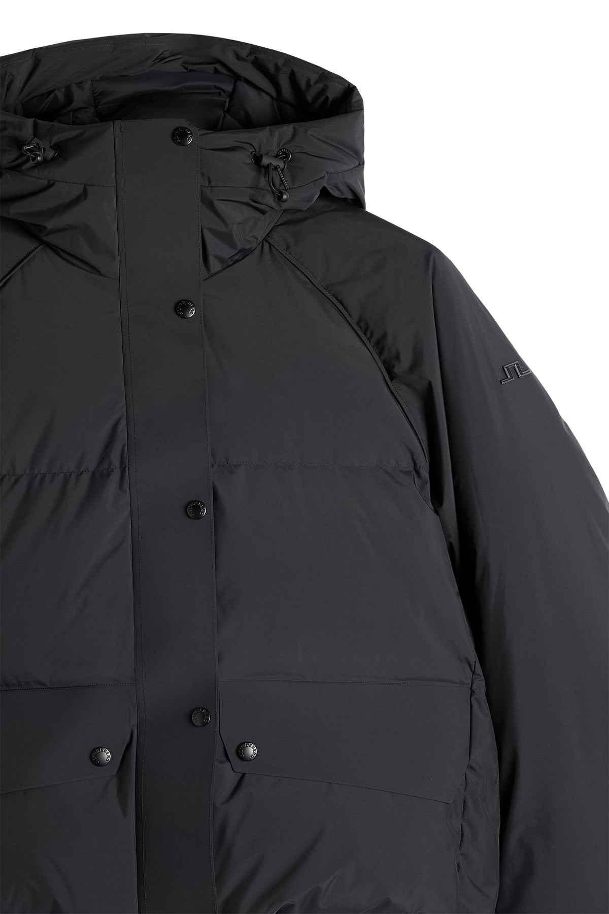 Close-up: Zwarte Lea Down Jacket met capuchon, drukknoopsluiting en Bridge-logo op de linkermouw.