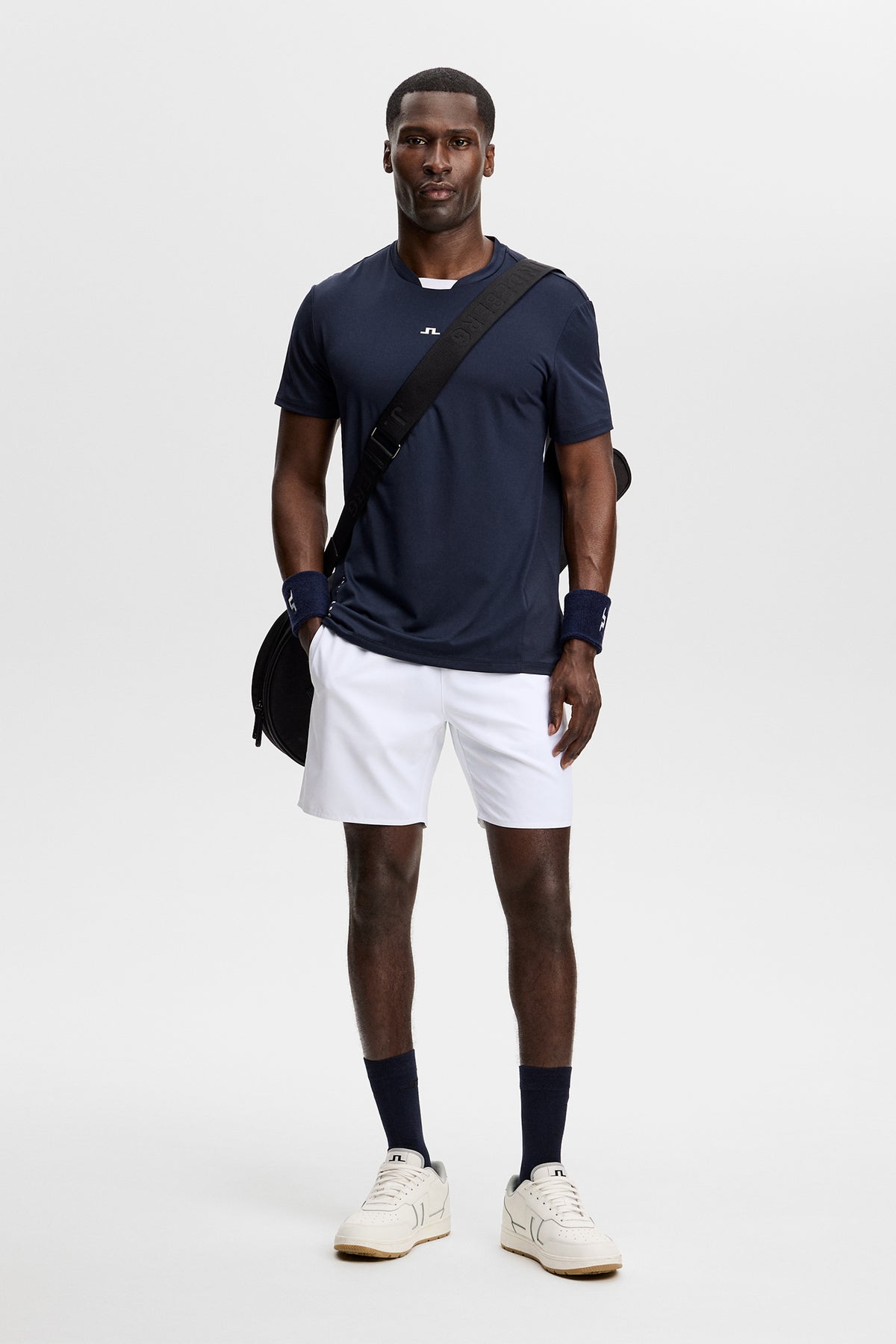 Forfra: Dennis T-shirt i JL Navy med centralt Bridge-logo, båret med hvide shorts.