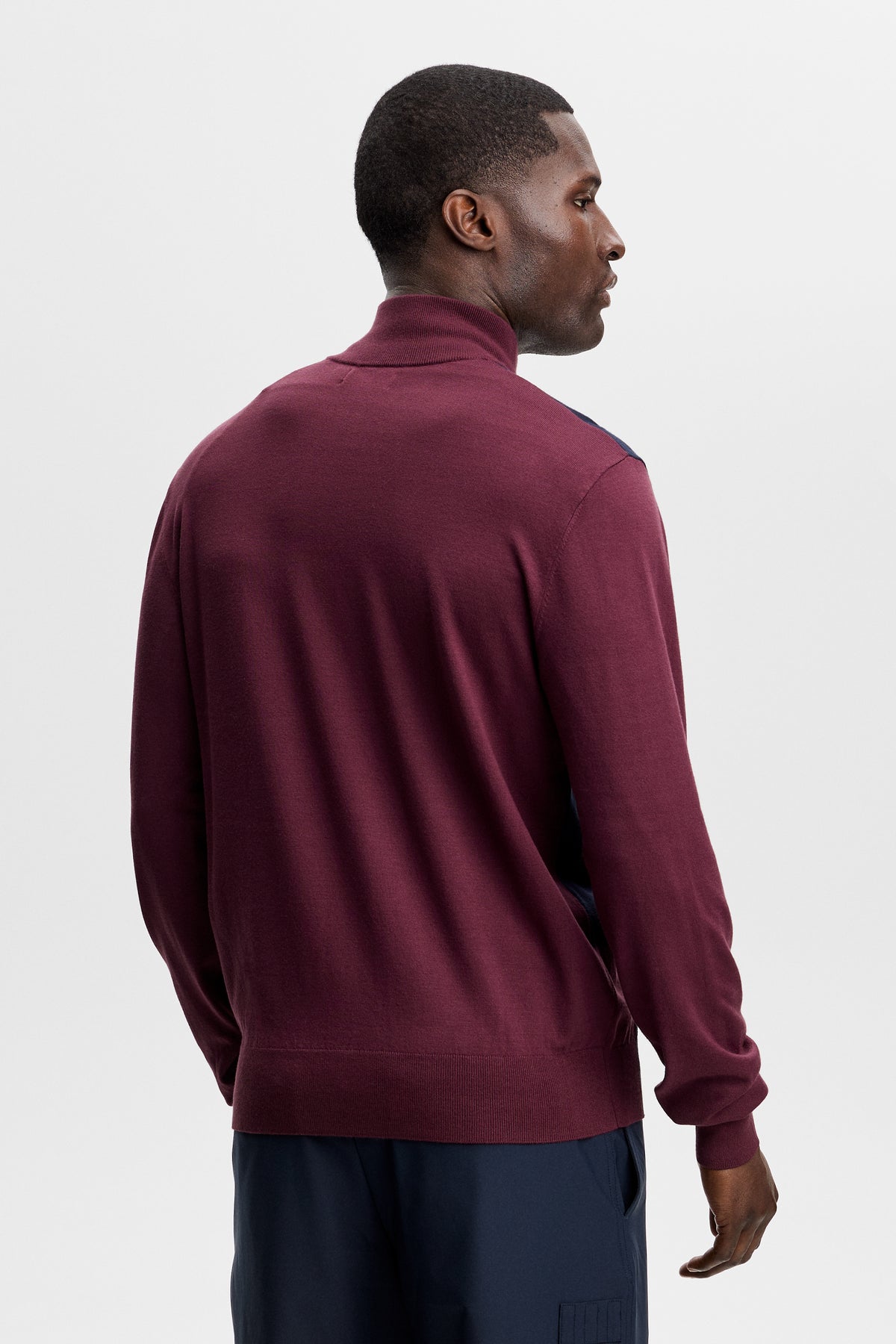 Rückansicht: Weinroter Kendrick Knitted Zip Sweater, getragen mit dunkler Hose im Studio.