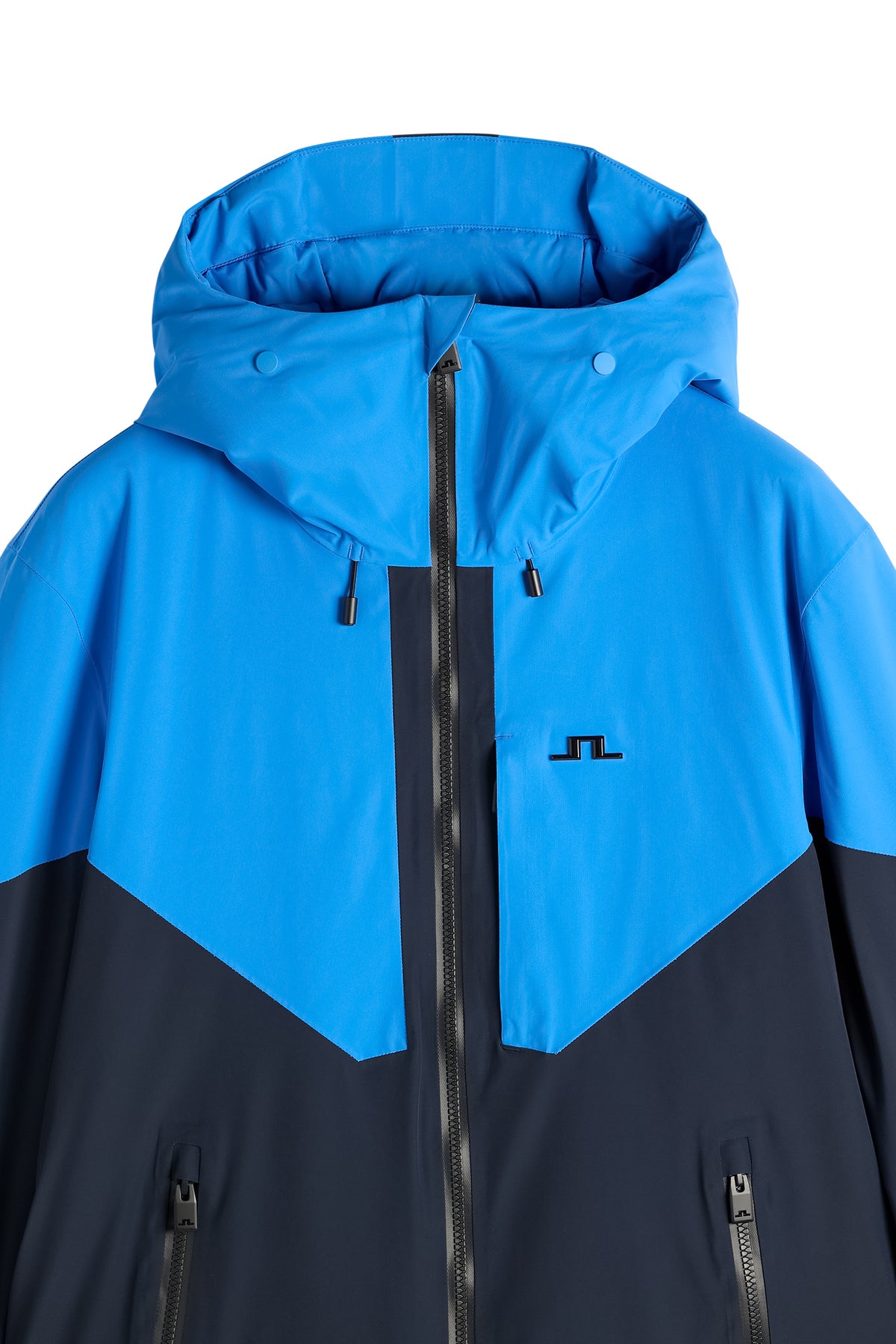 Detailansicht: Caldwell Jacket in Sonic Blue mit Kapuze, Reißverschluss und Bridge-Logo auf der Brust.