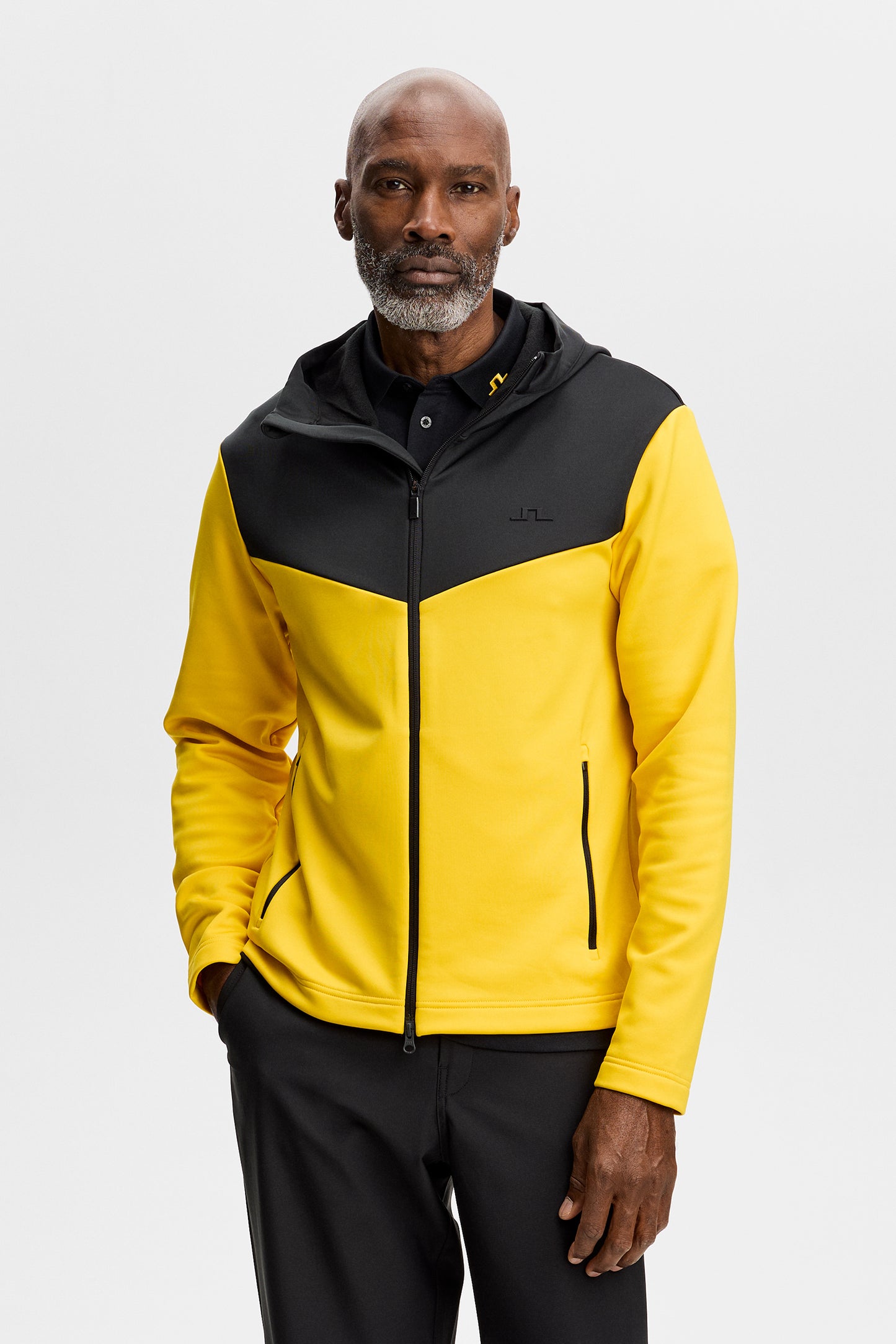 Set forfra: Maclean Zip Hood i gul og sort med tovejslynlås, hætte og Bridge-logo på brystet.