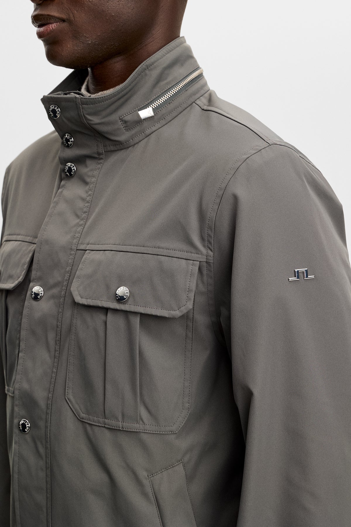 Close-up of the Bailey Recy Poly Jacket in Chimera, showing chest pockets, zippered collar, and sleeve Bridge logo.