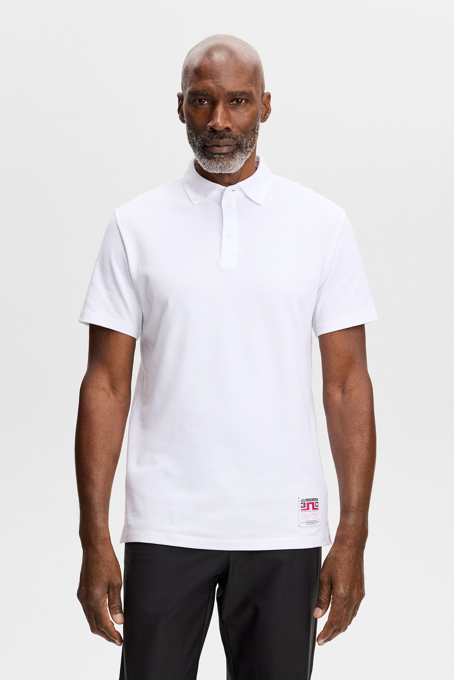 Vooraanzicht: Model draagt de Verse Button Down Polo in White met korte mouwen en button-downkraag.