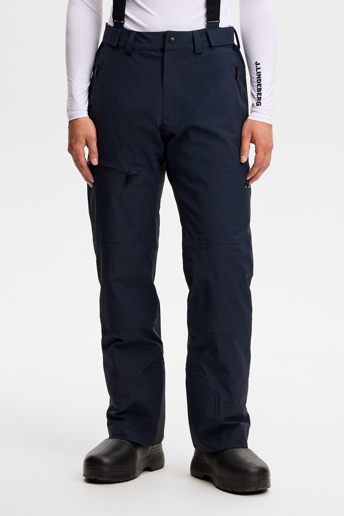 Vorderansicht: Crue Suspender Pant in JL Navy mit Hosenträgern und Reißverschlusstaschen an einem Model.