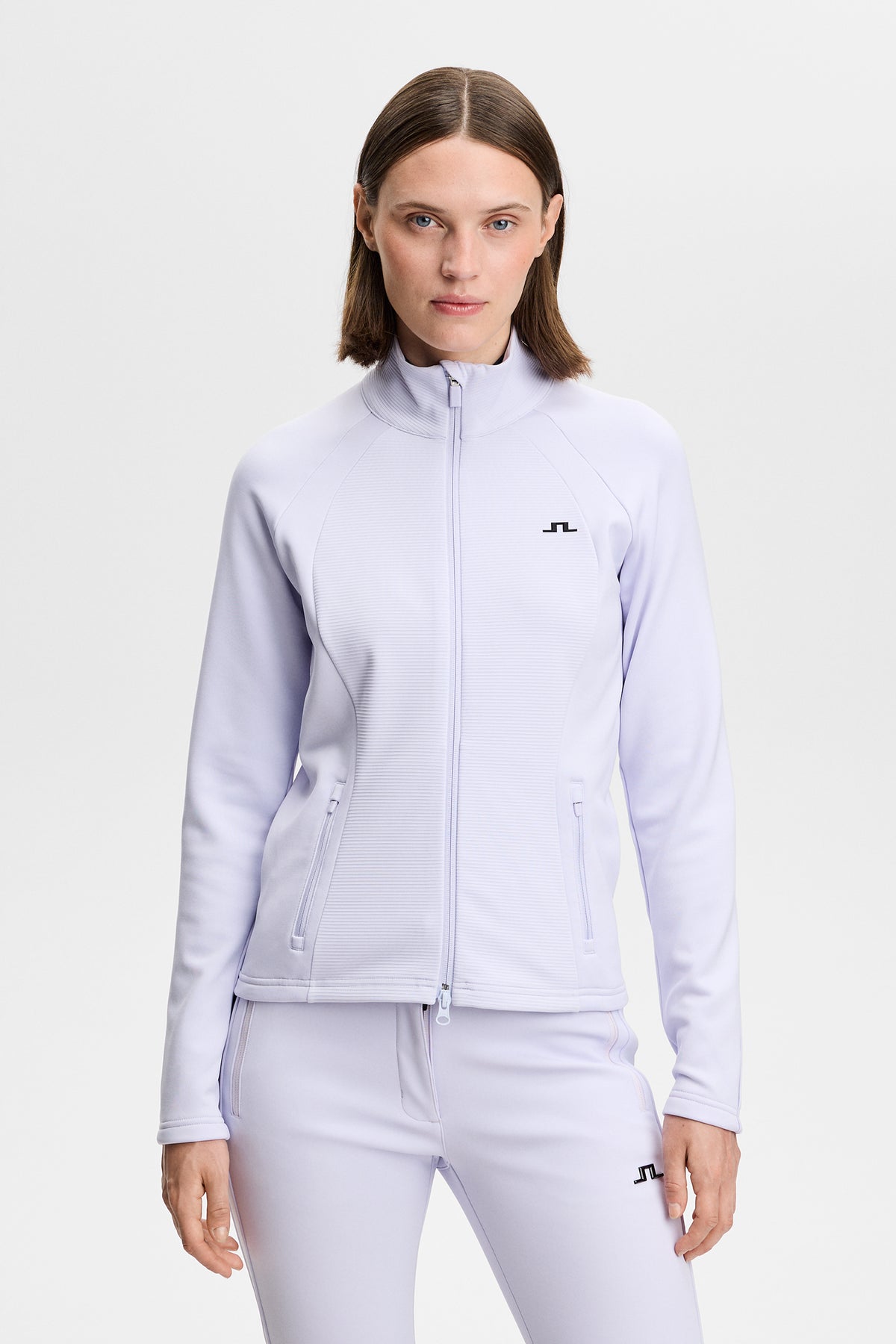 Vooraanzicht: Model draagt de Mireya Full Zip Mid Layer in Purple Heather met ritssluiting en Bridge-logo op de borst.