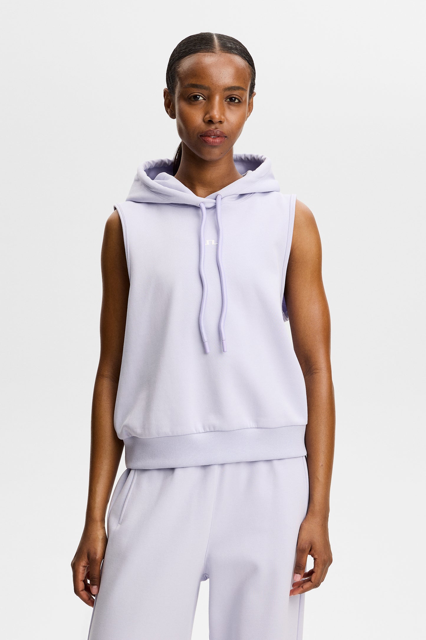 Vorderansicht: Sarah Sleeveless Hood in Hellviolett mit Kapuze, Kordelzug und Bridge-Logo auf der Brust.