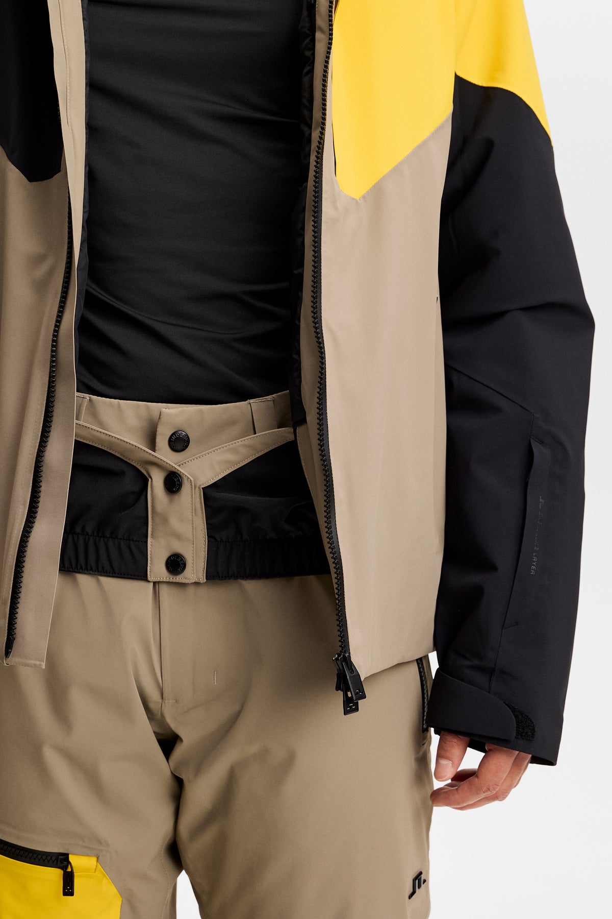 Nærbillede: Caldwell Jacket i Bumblebee, båret åben med synligt sneskørt og matchende skibukser.