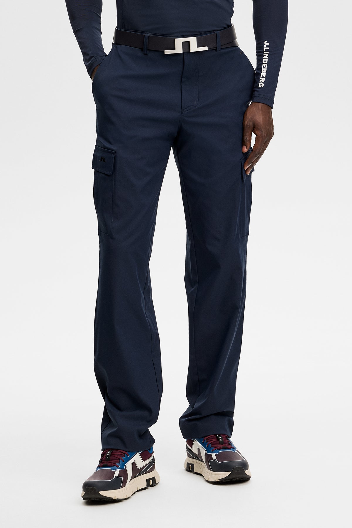 Model wearing the Logan Cargo pant in JL Navy, front view showing cargo side pockets in a studio setting.