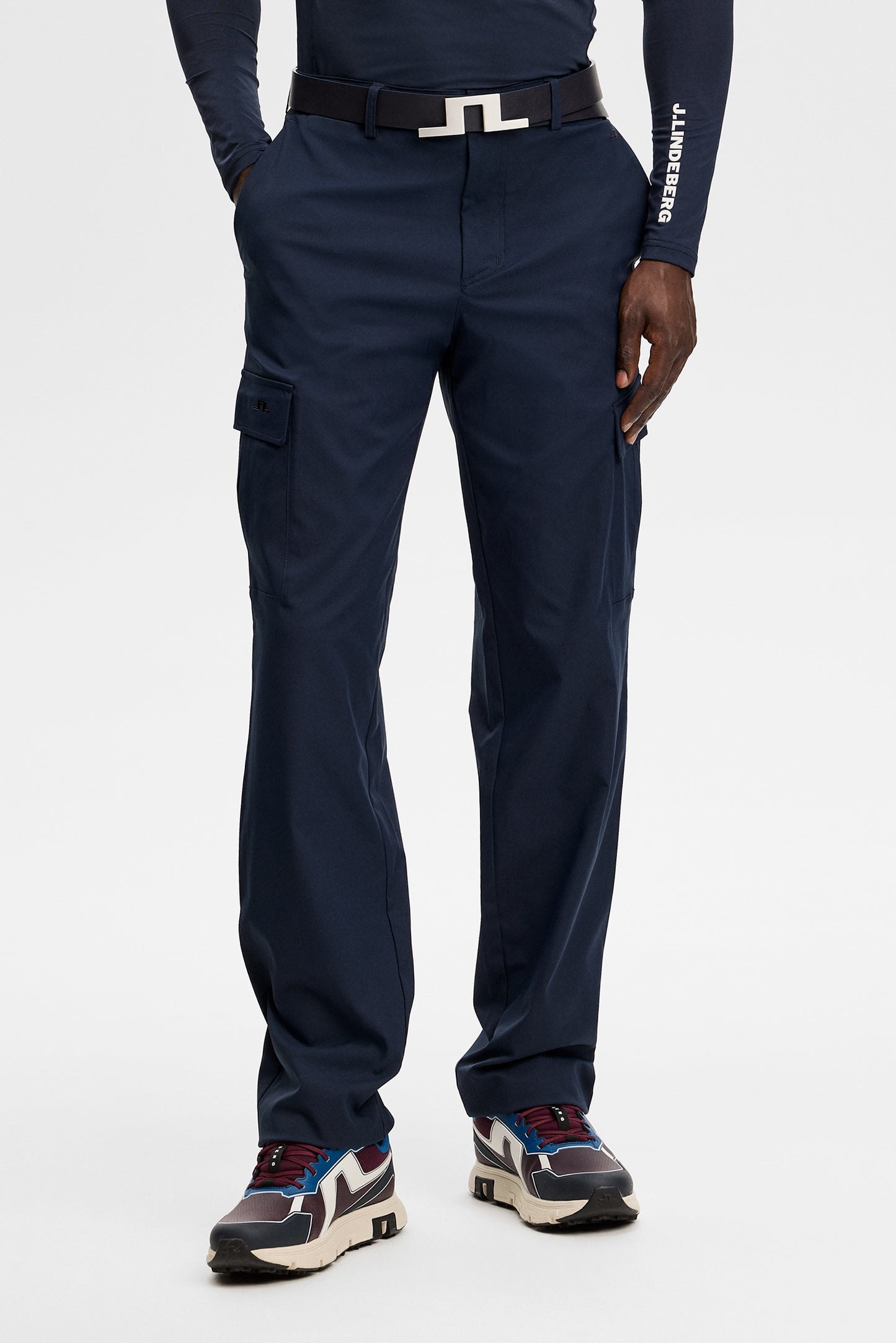 Model wearing the Logan Cargo pant in JL Navy, front view showing cargo side pockets in a studio setting.