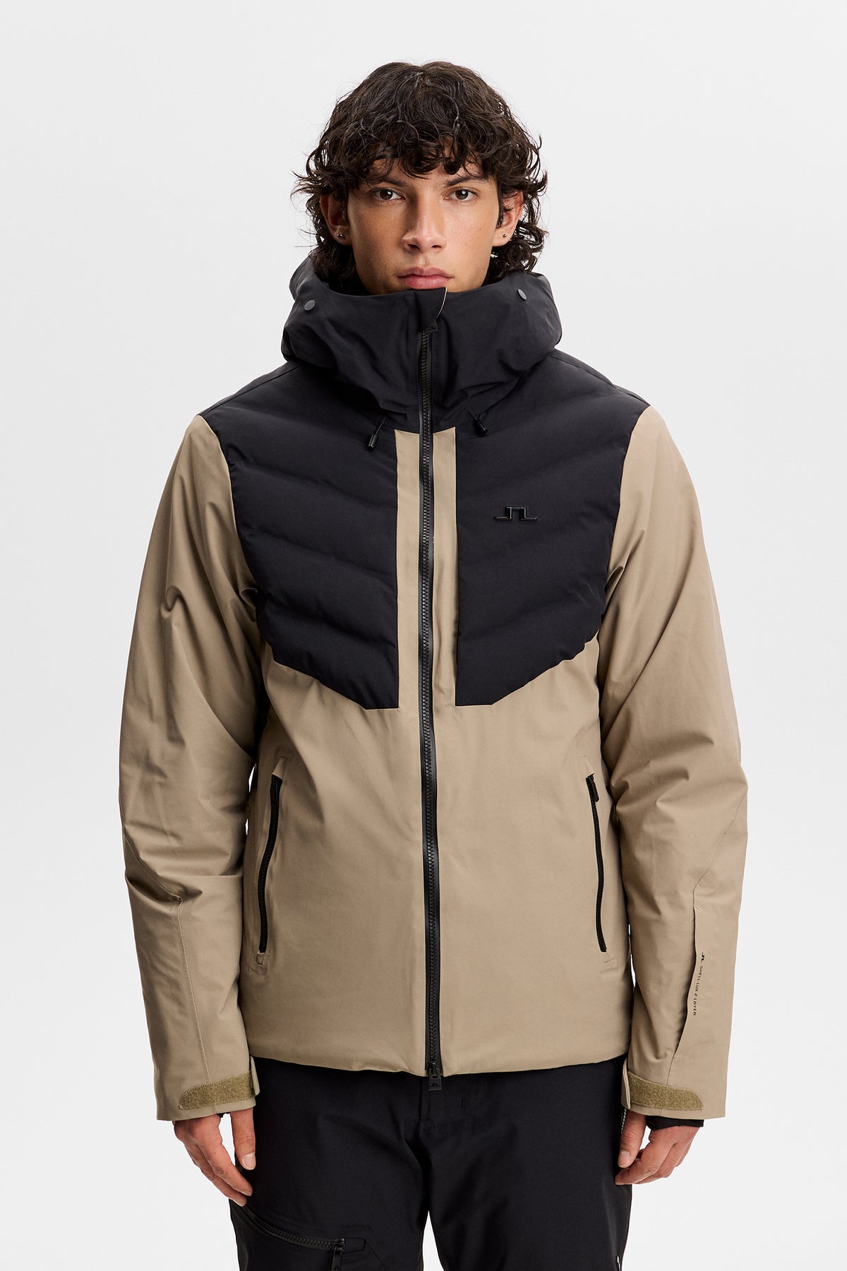 Set forfra: Blackwell Jacket i Brindle med sort quiltet brystpanel, hætte og Bridge-logo på brystet.