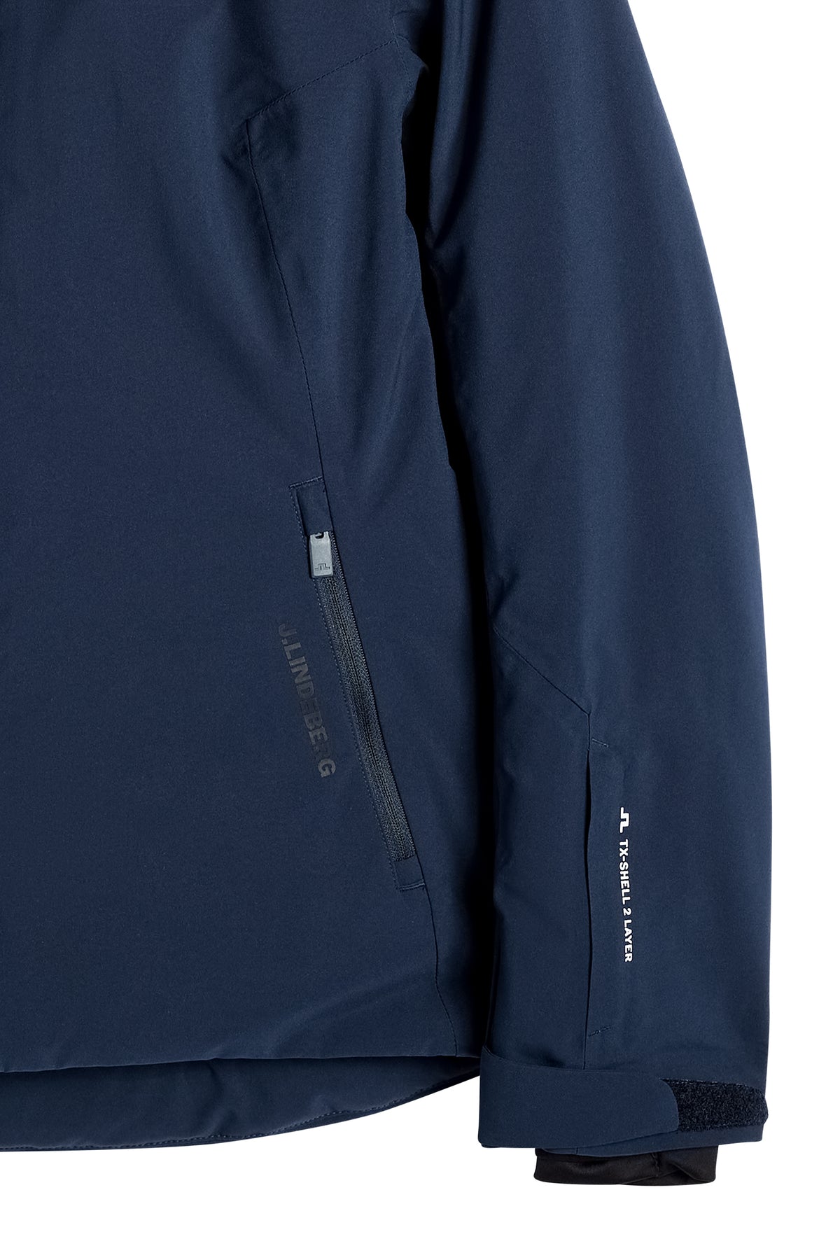 Detailansicht: Lilia Jacket in JL Navy mit Reißverschlusstasche, J.LINDEBERG-Schriftzug und verstellbarem Ärmelbündchen.