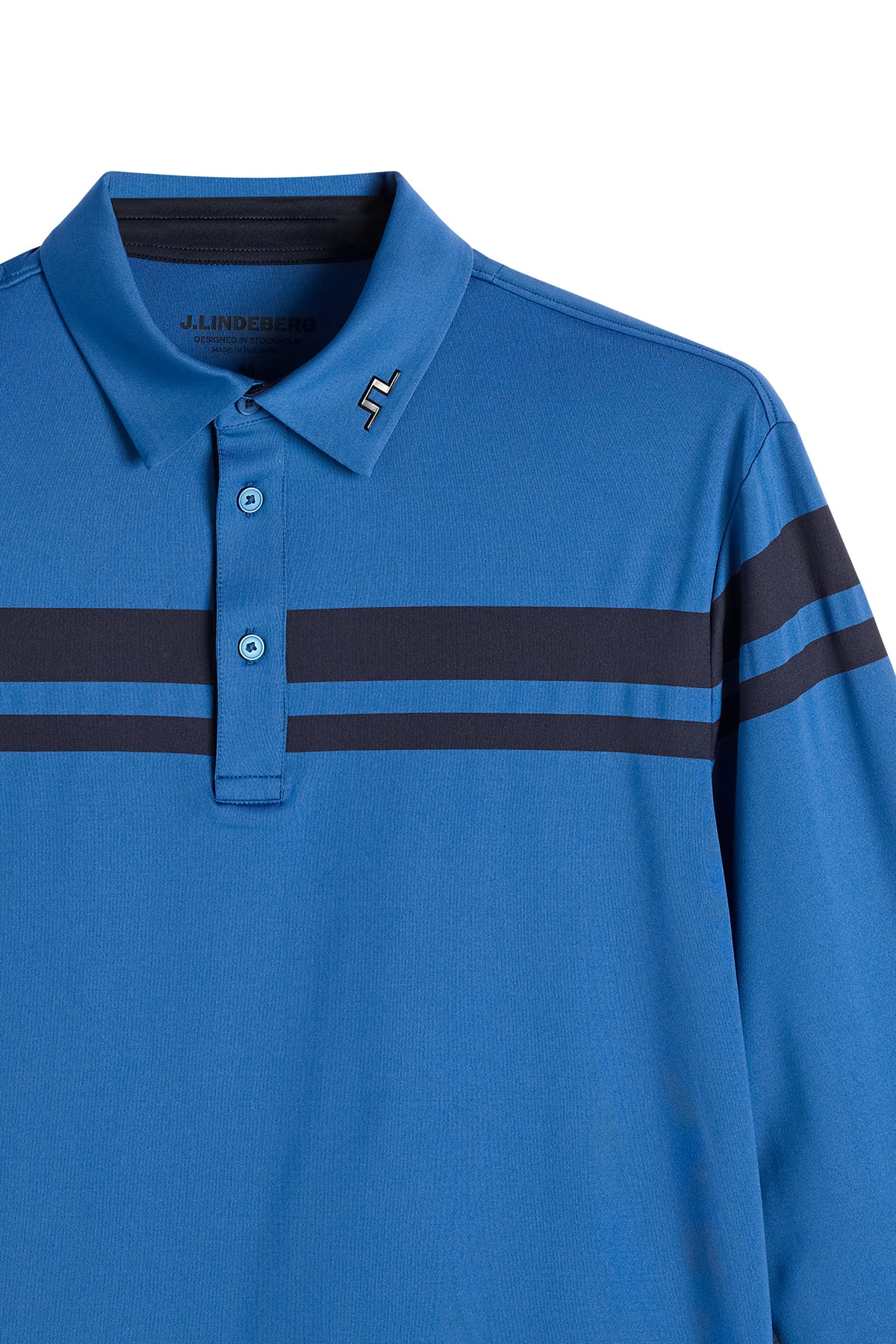 Nærbillede: Blå Kenny LS stripe polo med knaplukning, vandrette striber på brystet og Bridge-logo i metal på kraven.