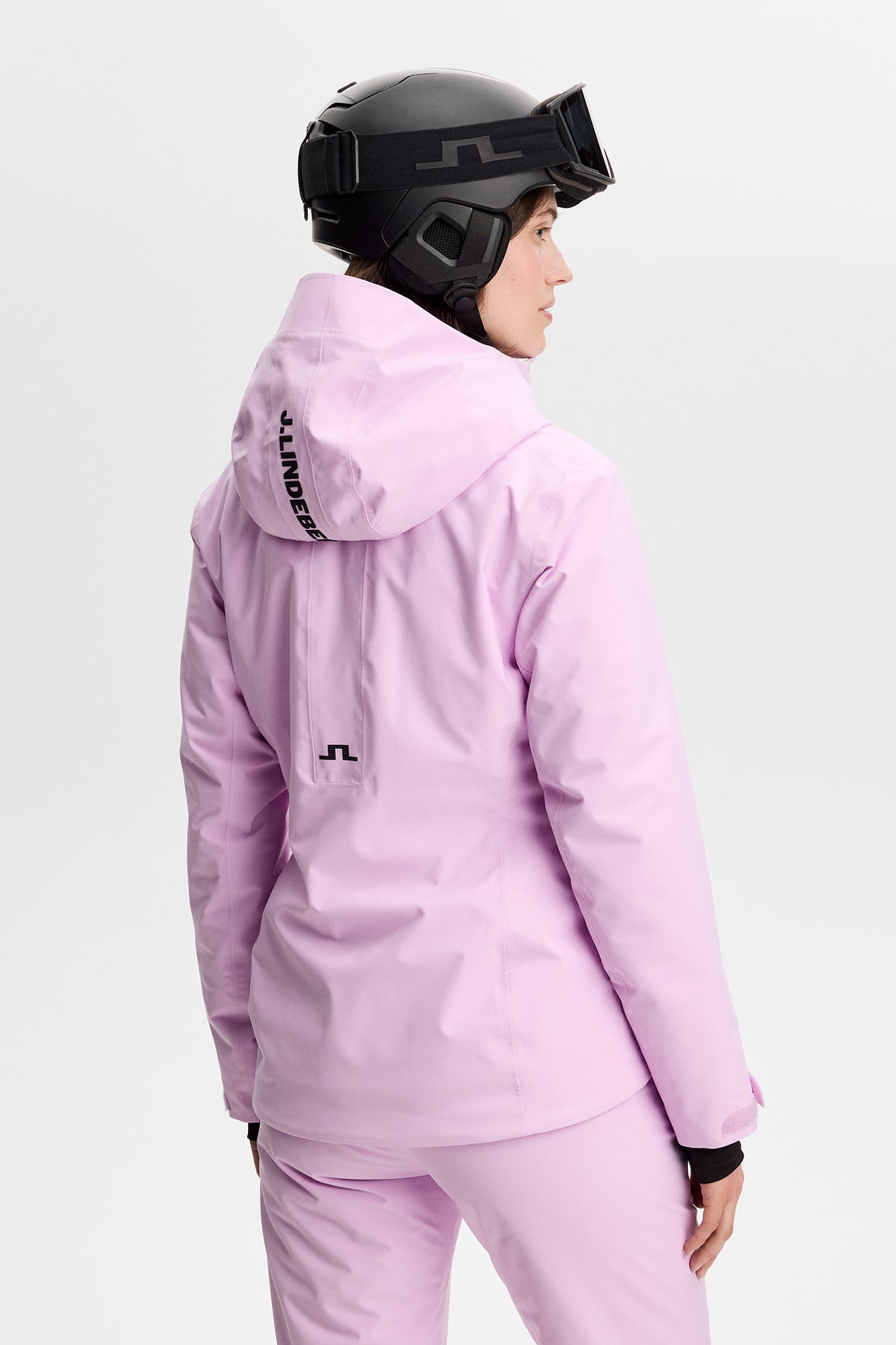 Set bagfra: Lilia Jacket i Orchid Bouquet med hætte, J.LINDEBERG-logo og Bridge-logo på ryggen.