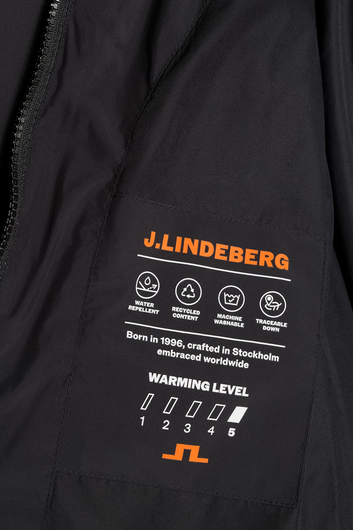 Close-up: Zwarte Lea Down Jacket met binnenlabel met J.LINDEBERG-logo en functionele details.