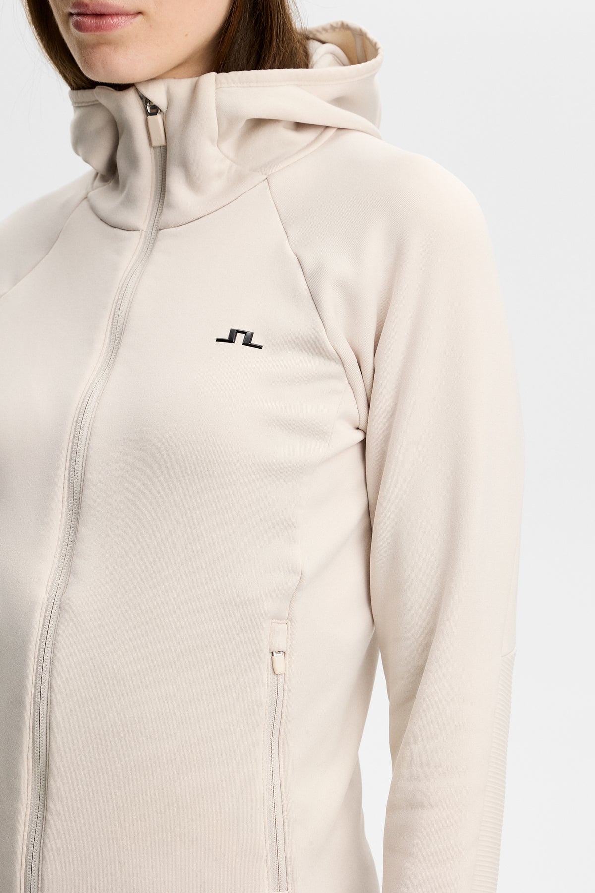 Close-up of the Portia Polartec Hood in Moonbeam, showing the hood, zipper, and Bridge logo on the chest.