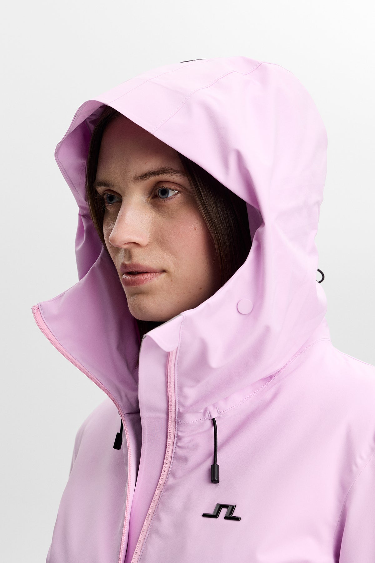 Nærbillede: Lilia Jacket i Orchid Bouquet med hætte, høj krave og Bridge-logo på brystet.