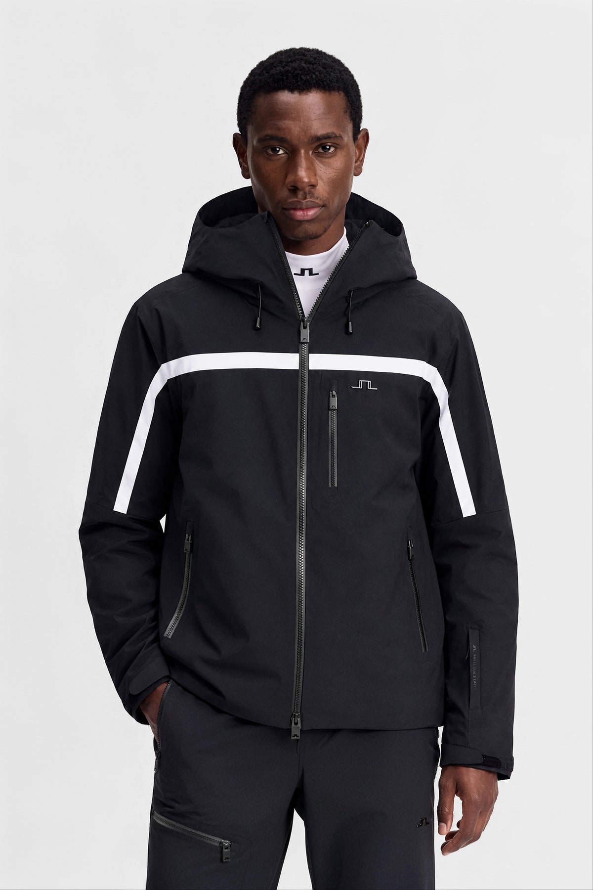Windsor Jacket in black, front view with a white chest stripe, hood, and Bridge logo.