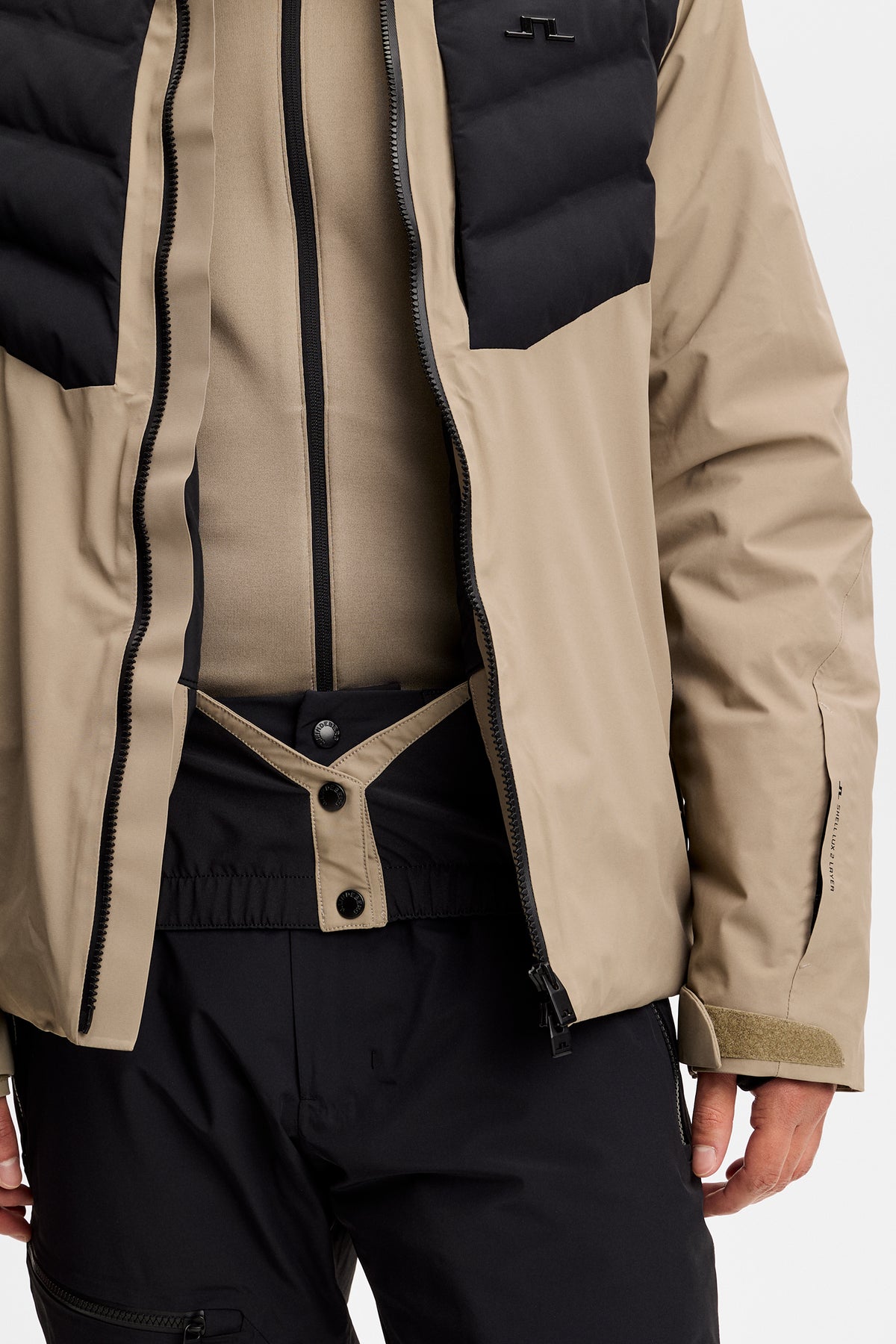 Nærbillede: Blackwell Jacket i Brindle båret åben med tovejslynlås, snefang og Bridge-logo på brystet.
